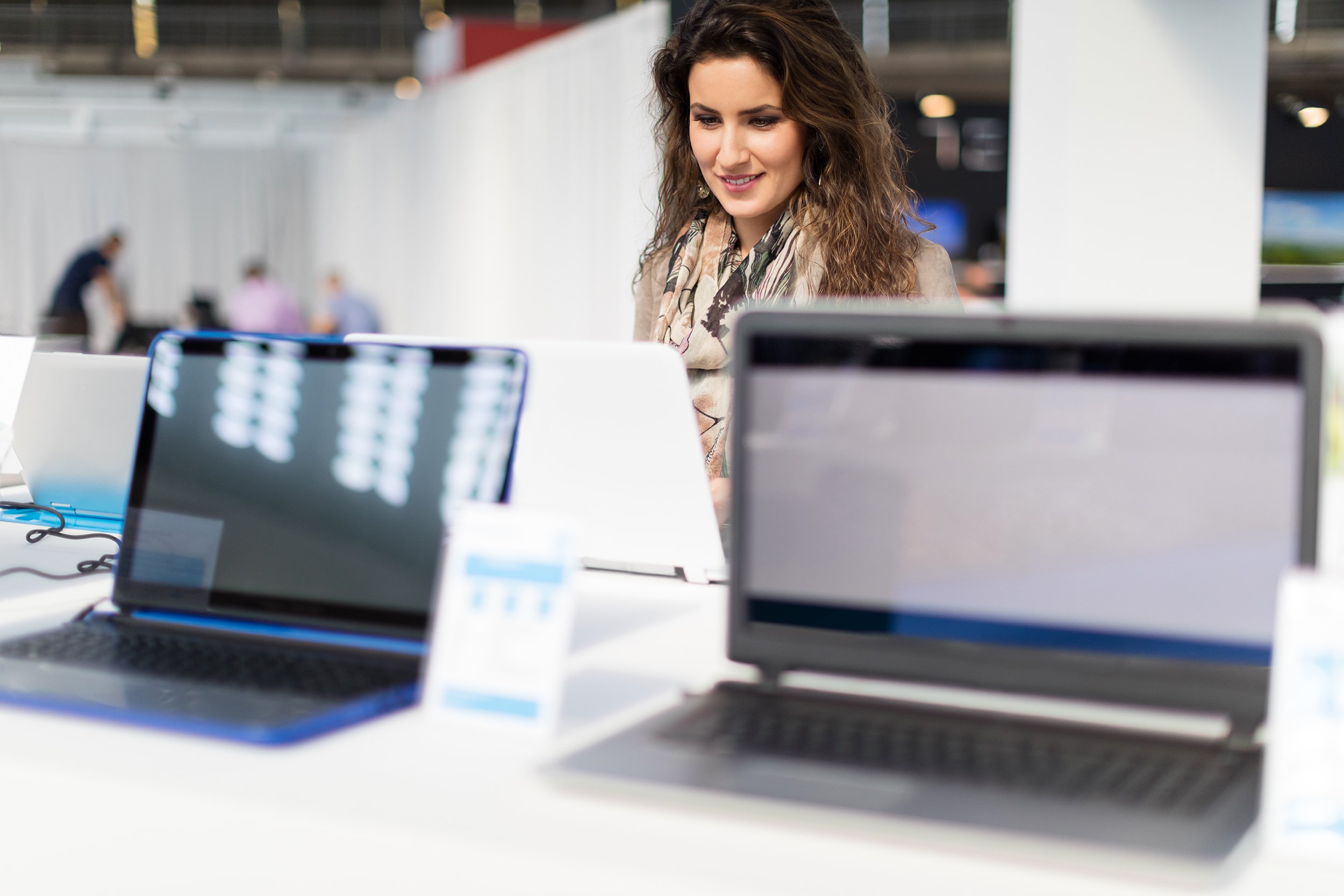 woman choosing laptop at store