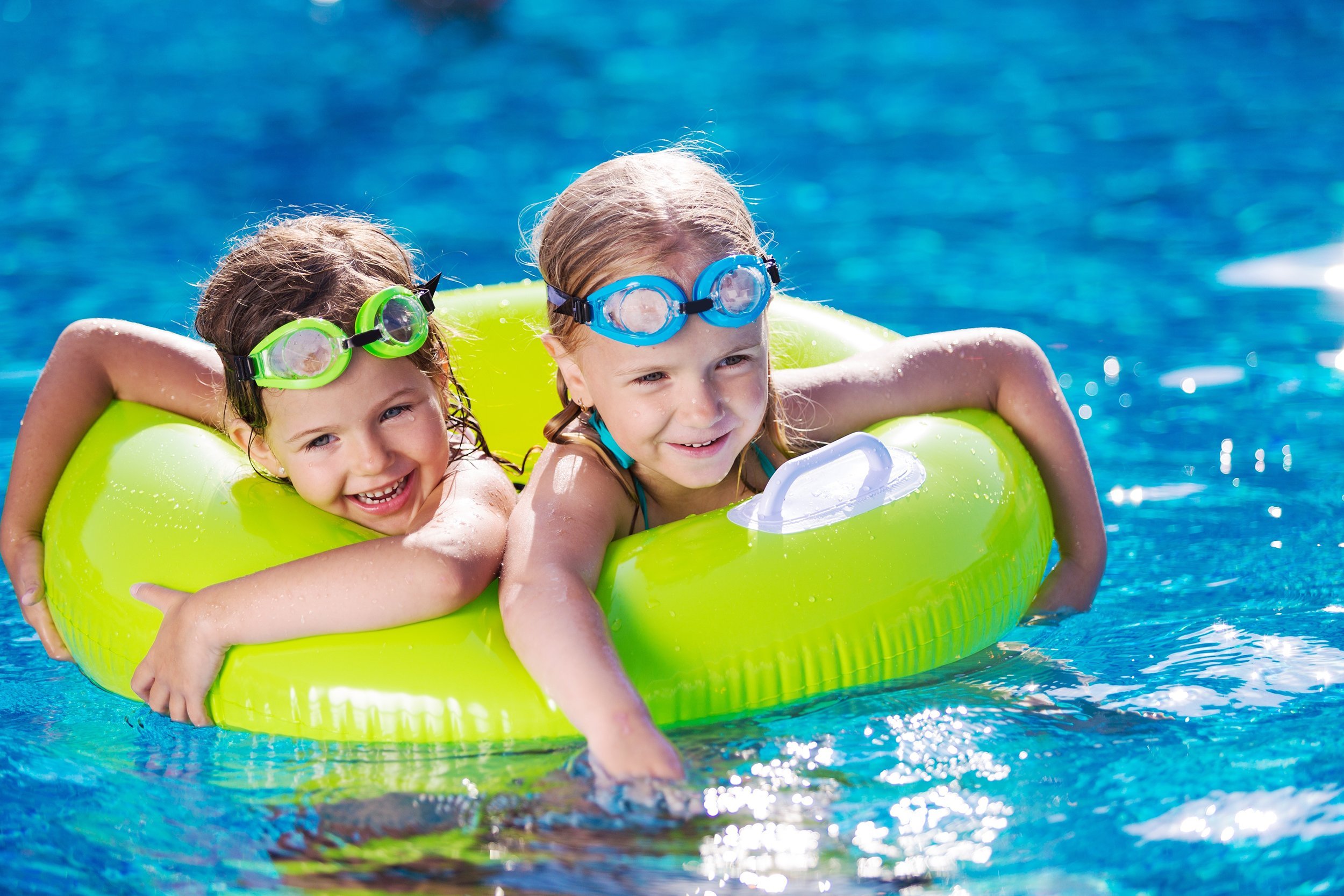 two kids in donut at the swimming pool