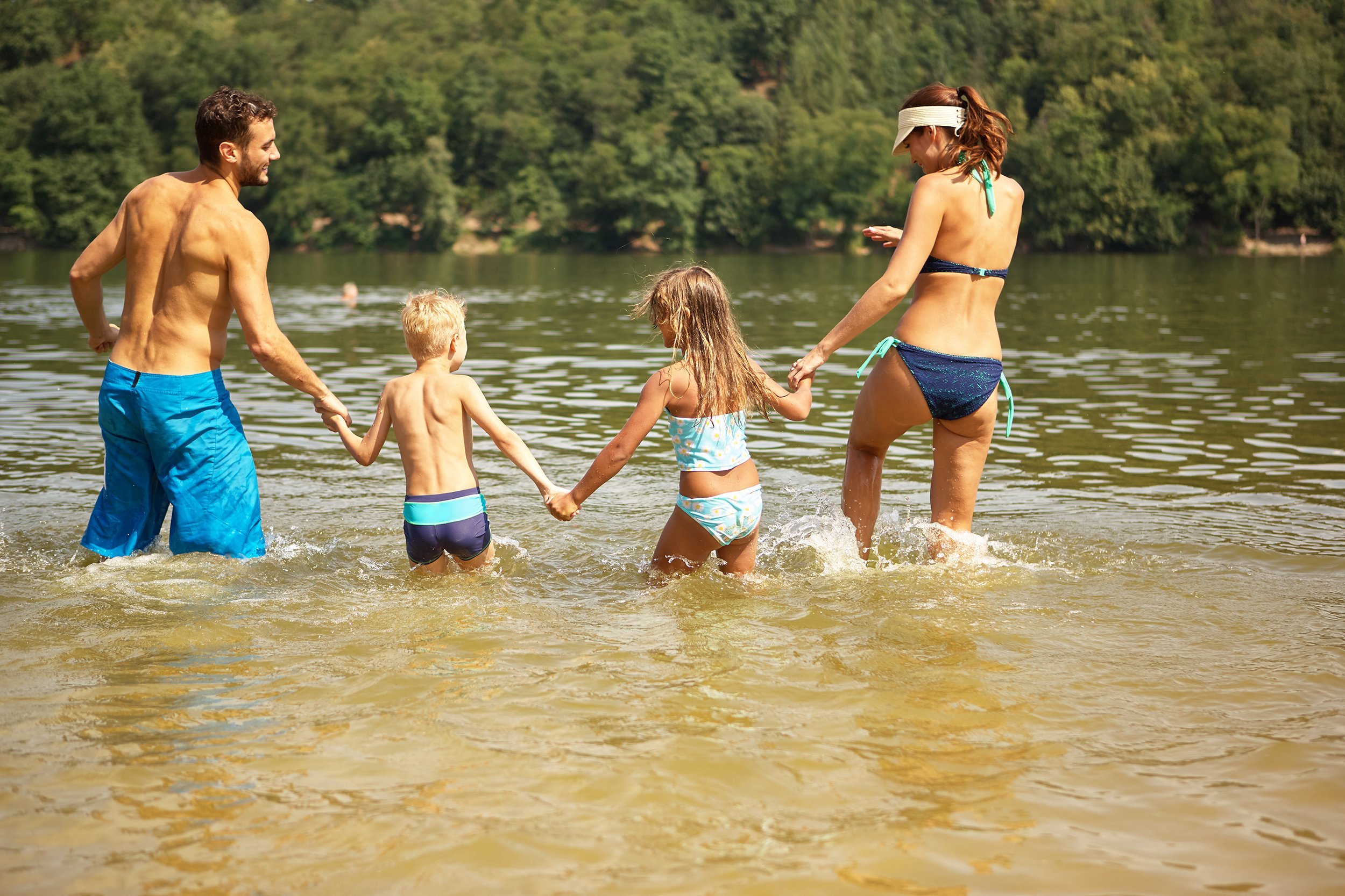 family with to kids bathing in summer at the lake