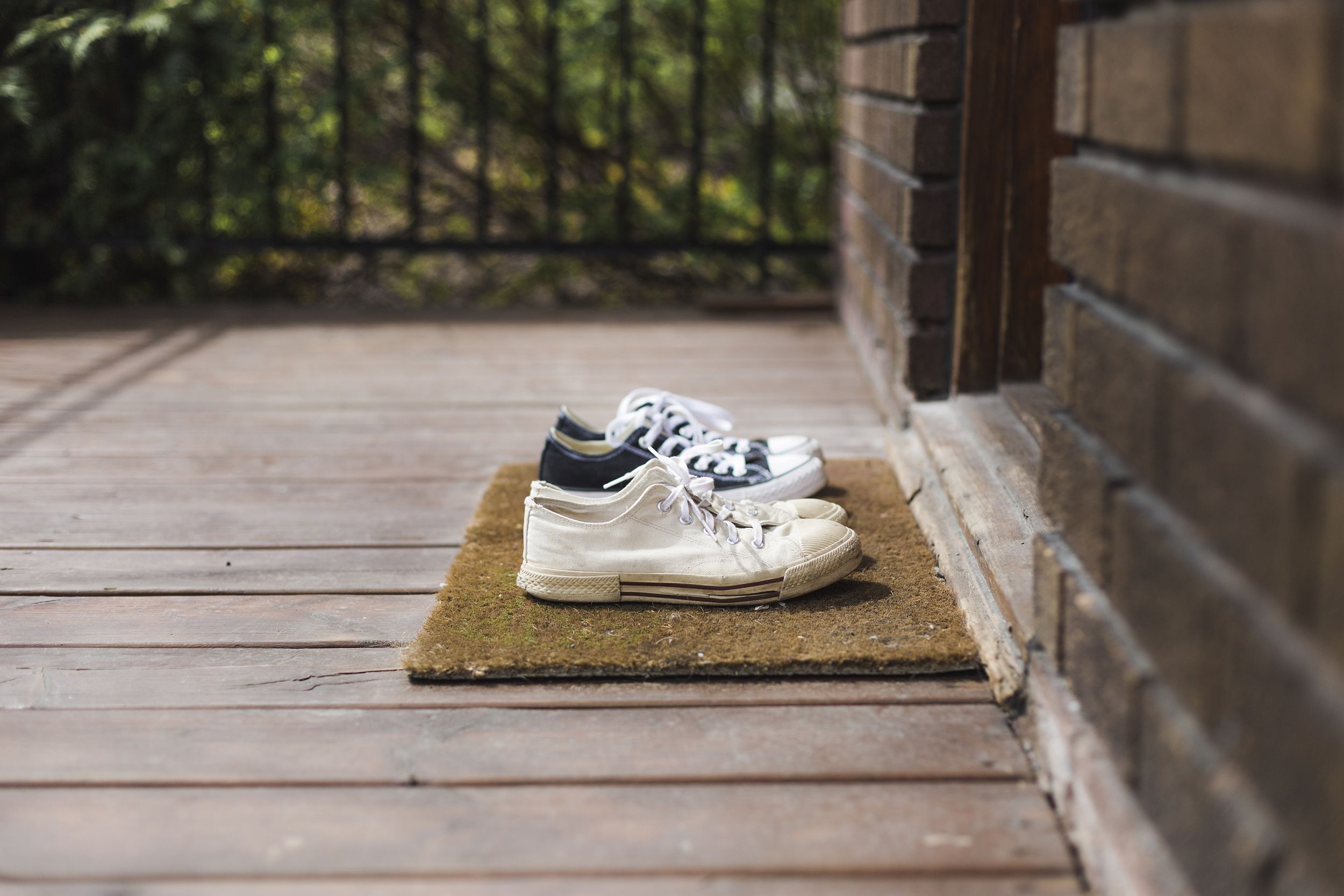 two pair of white and black sneakers shoes on a porch