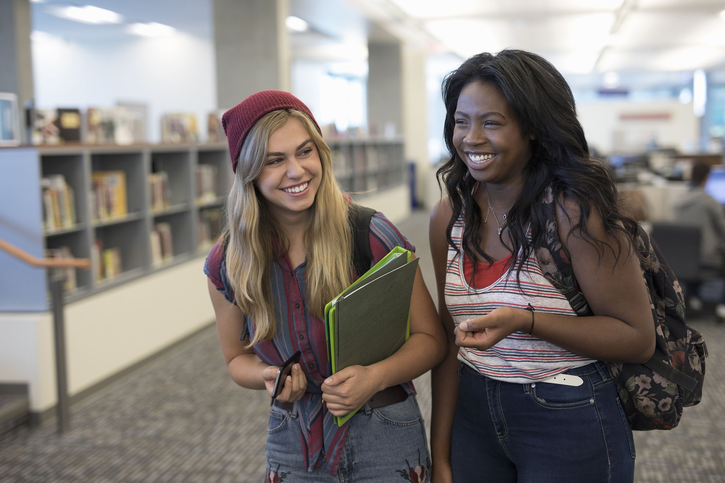 laughing female college students in library