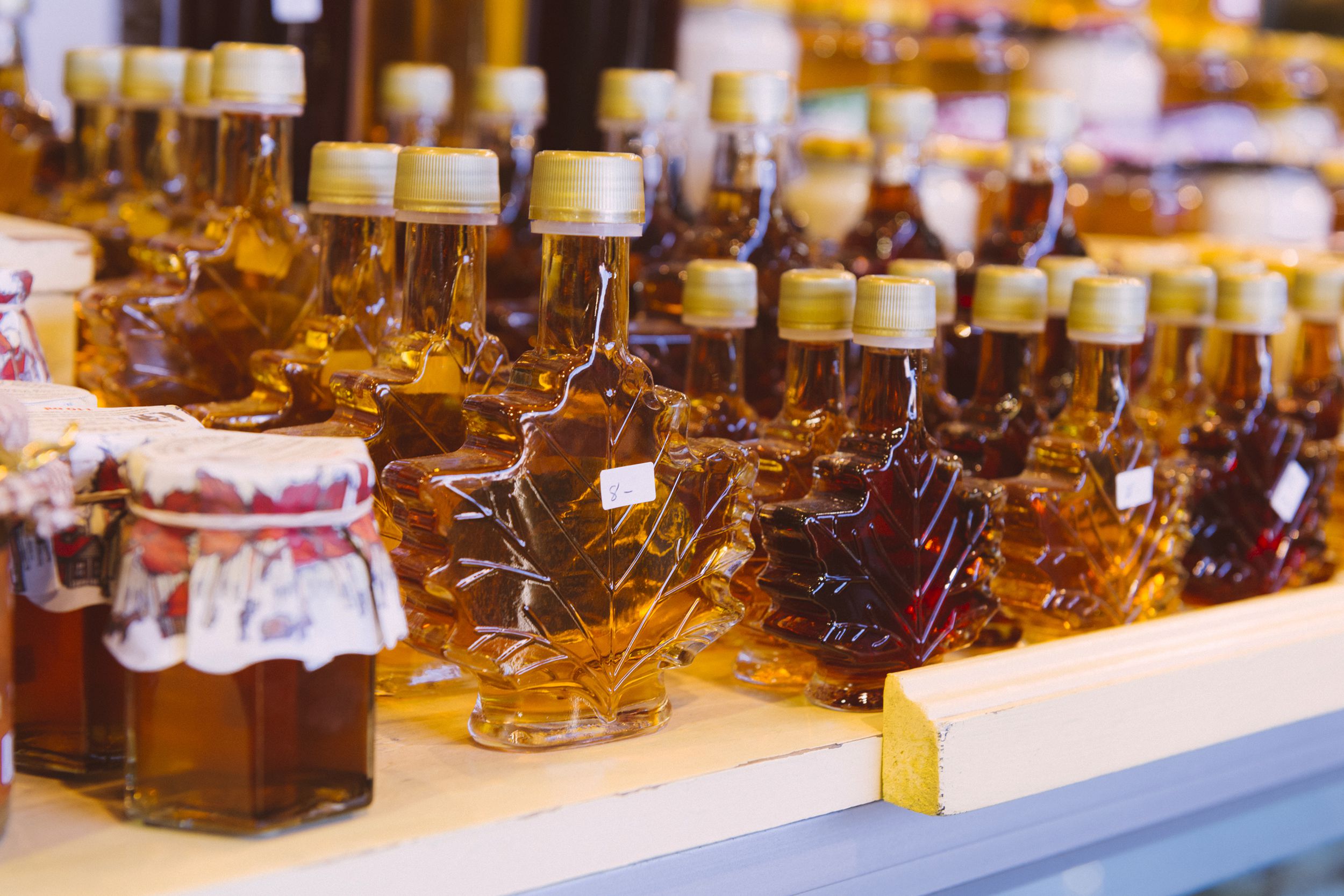 Canadian maple syrup in decorative leaf shaped bottles is for sale in a variety of sizes and grades from dark to light amber at the Atwater Market in Montreal, Quebec