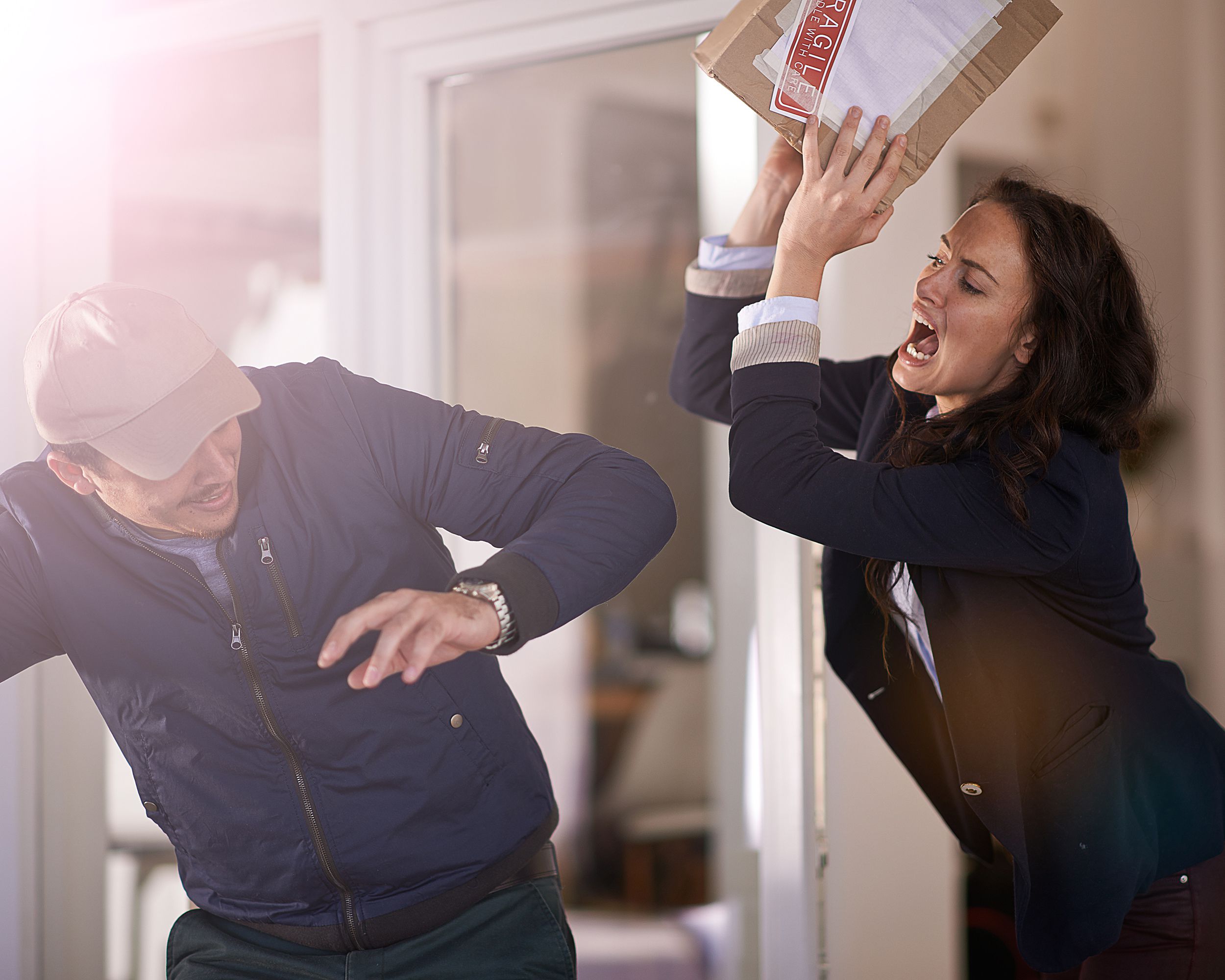 woman taking package and hitting delivery person