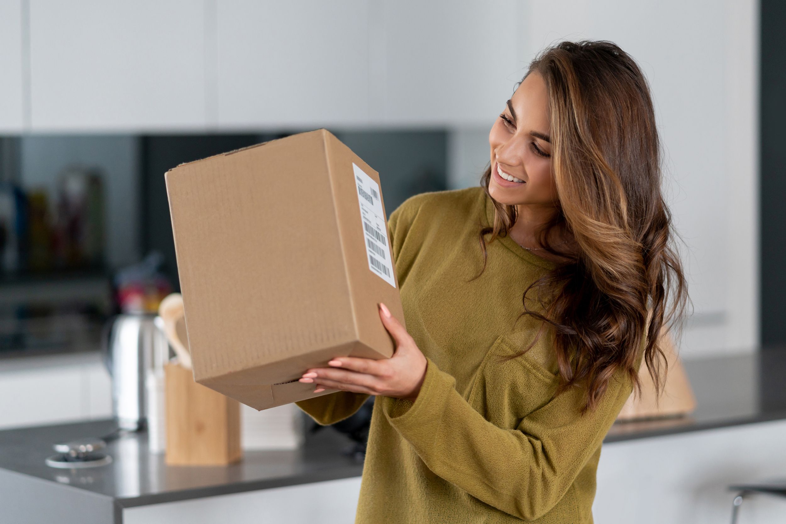 woman getting a parcel in the mail at home