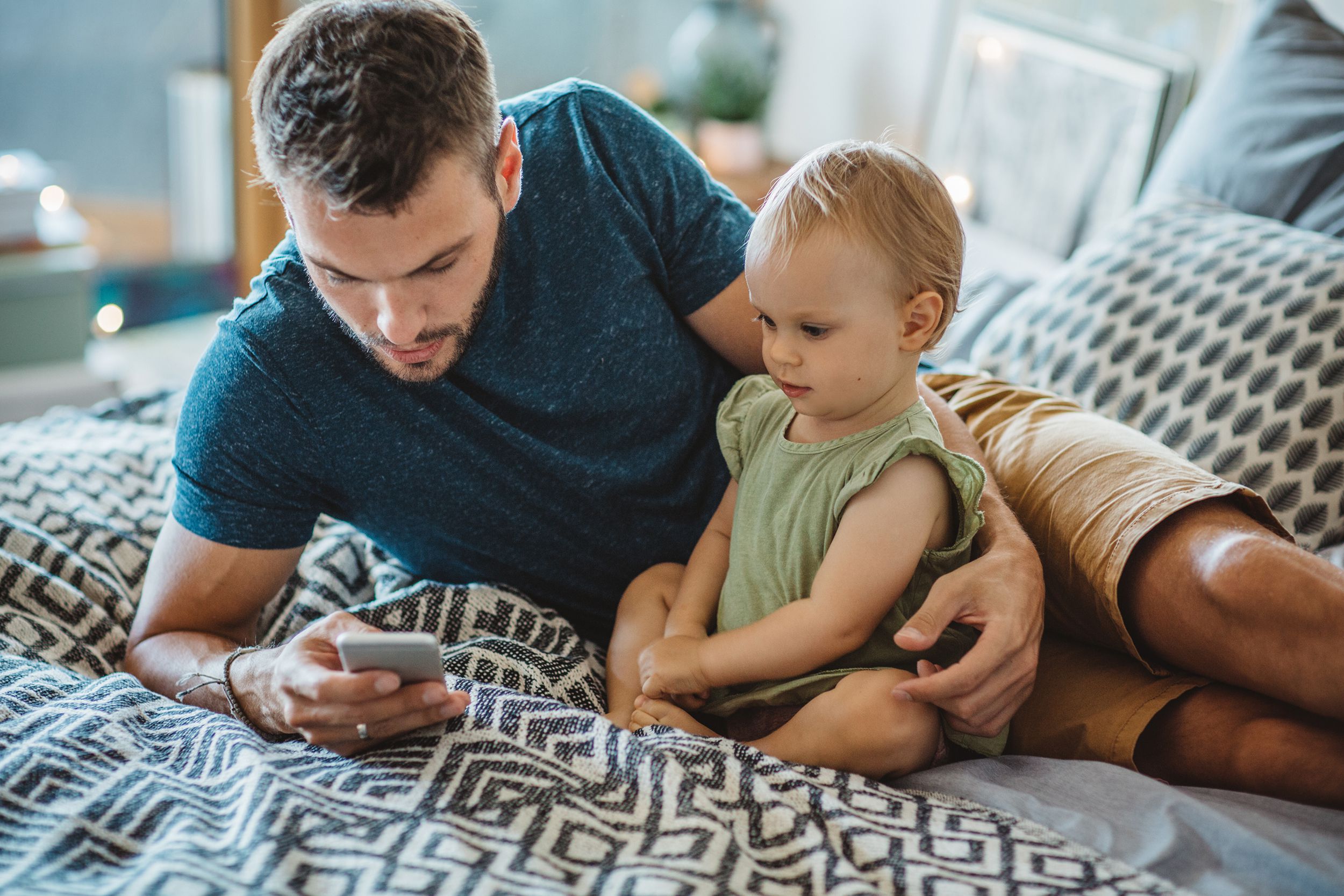 father shows little daughter something on phone