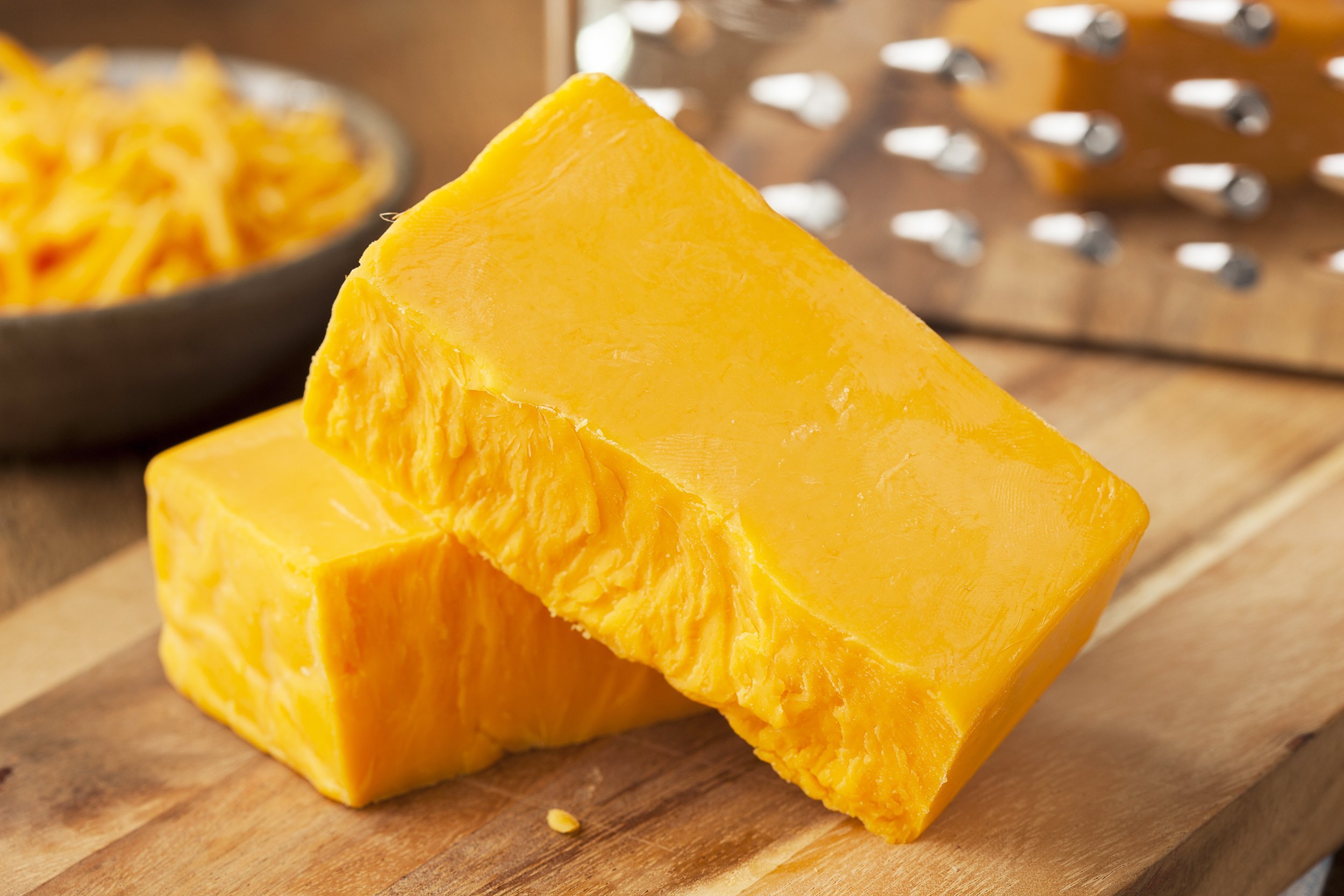sharp cheddar cheese block on a cutting board