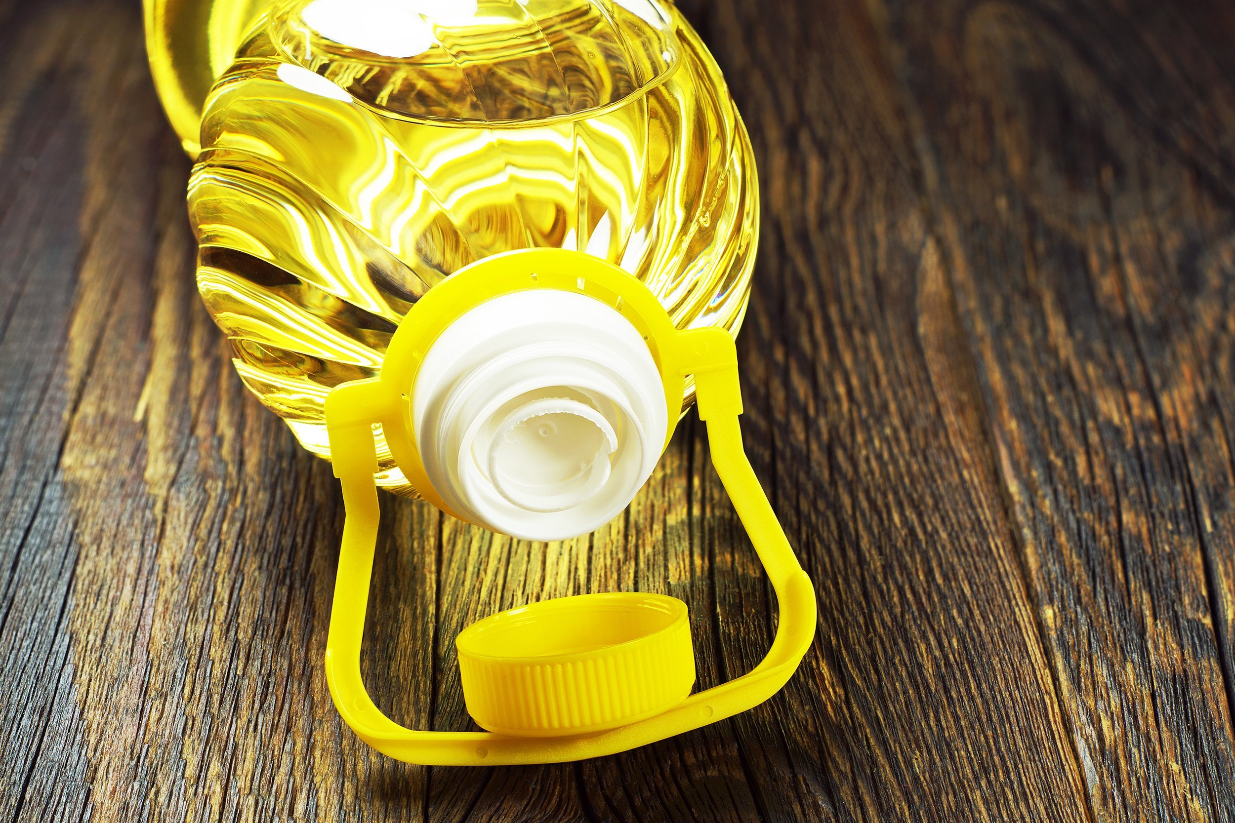 vegetable oil in plastic bottle on old wooden table
