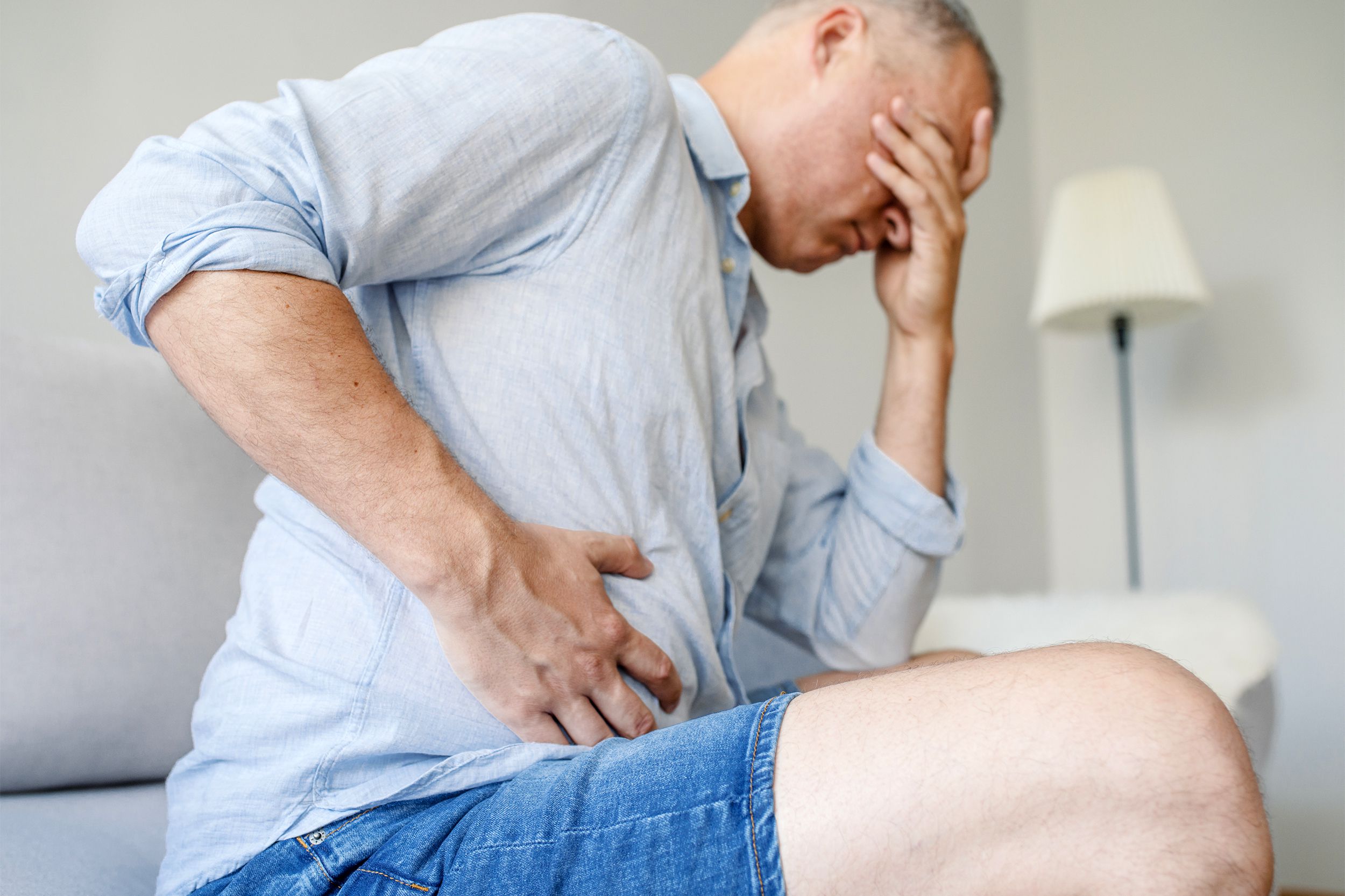 Man clutching his stomach in pain