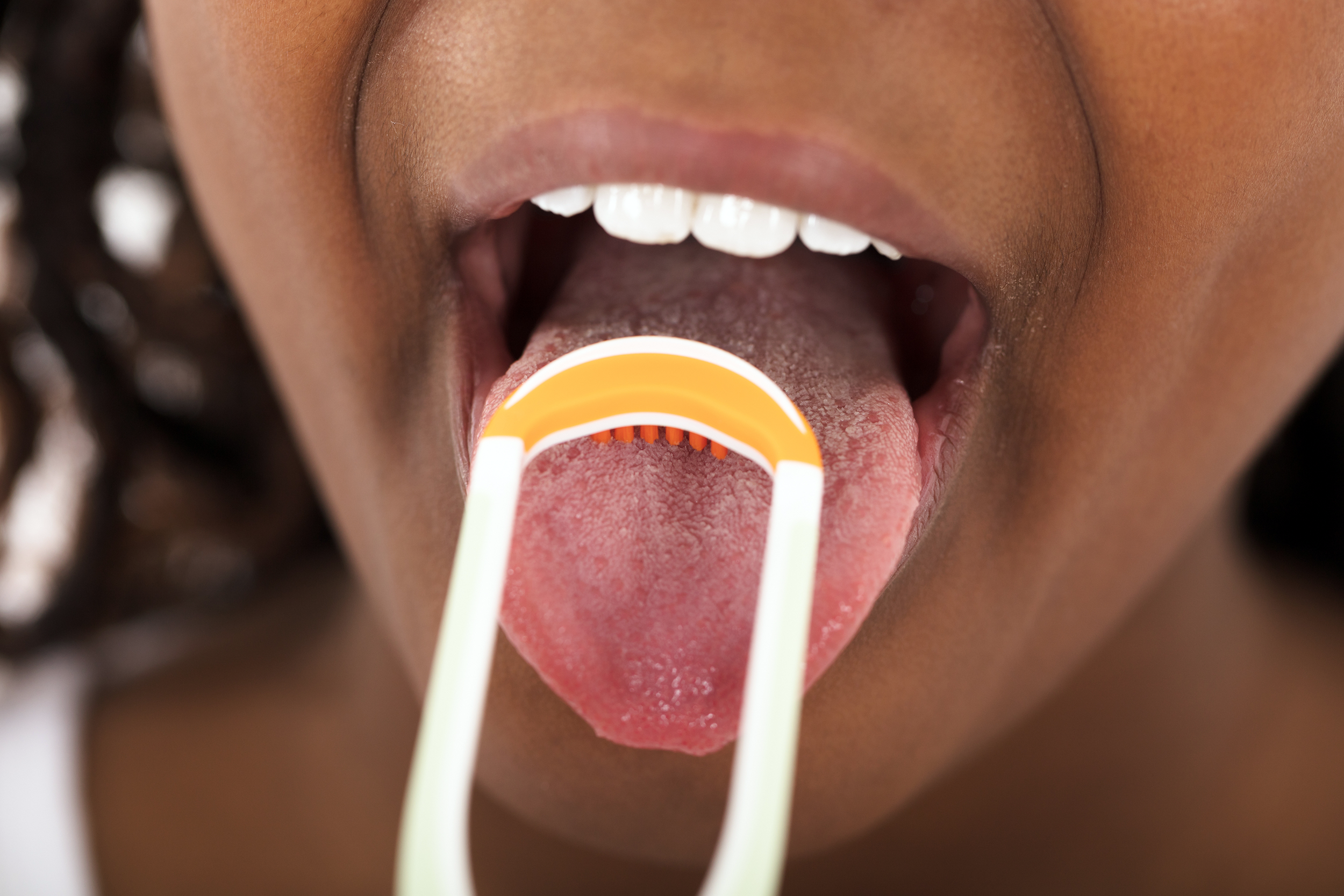 Girl scraping her tongue