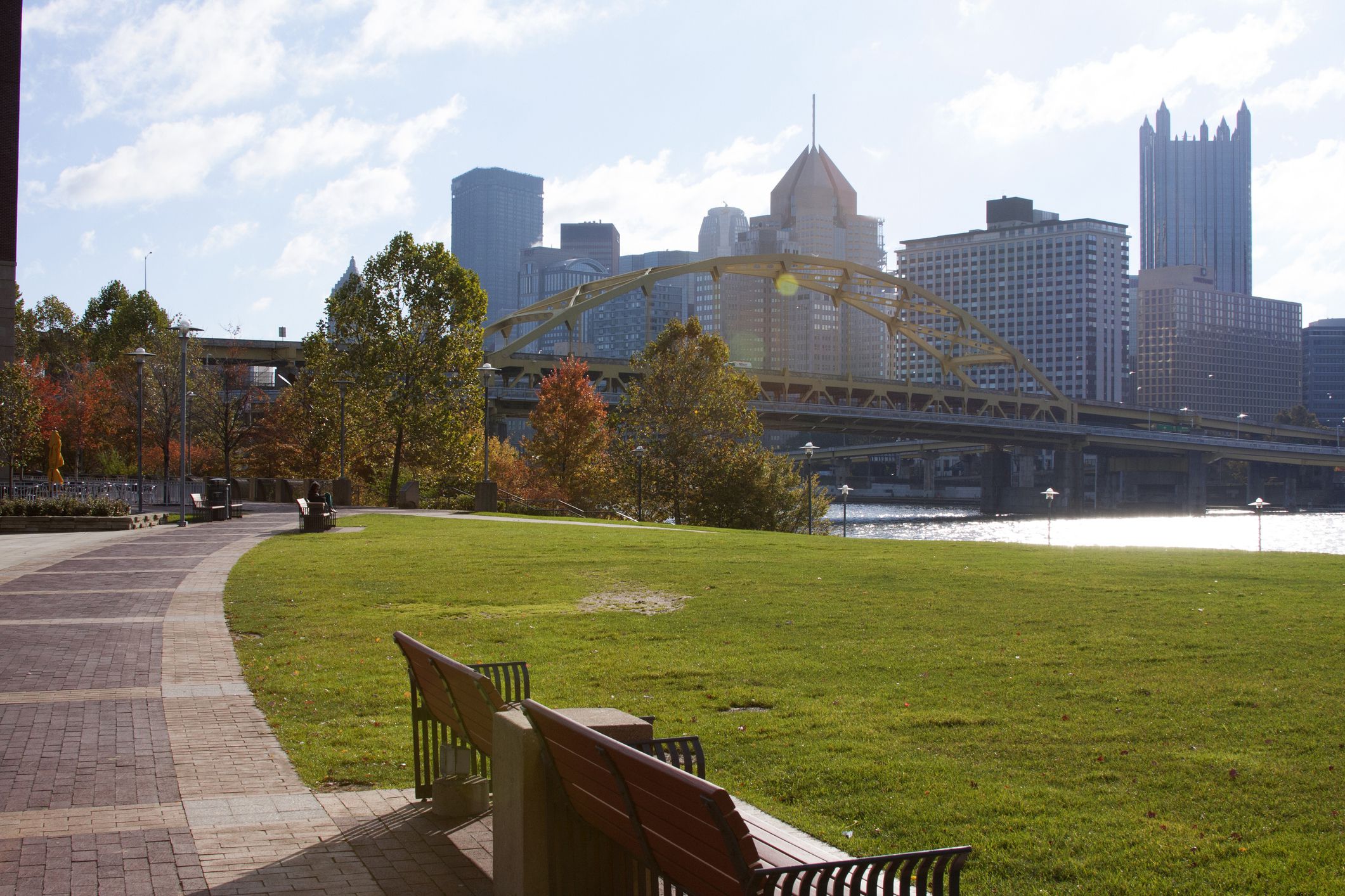 wide sidewalk in park with pittsburgh skyline in background