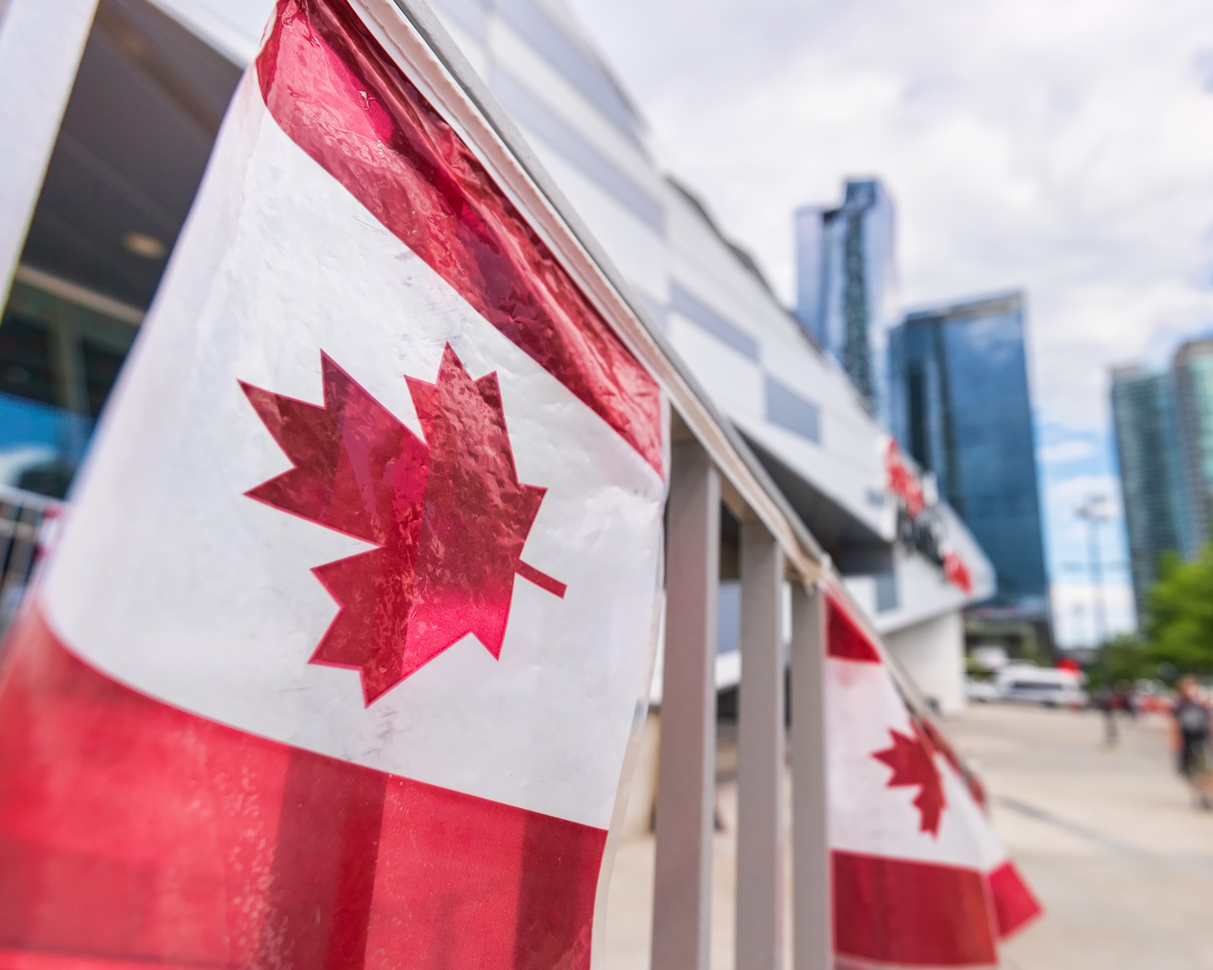 Canada plastic flag with blurred urban background in Toronto