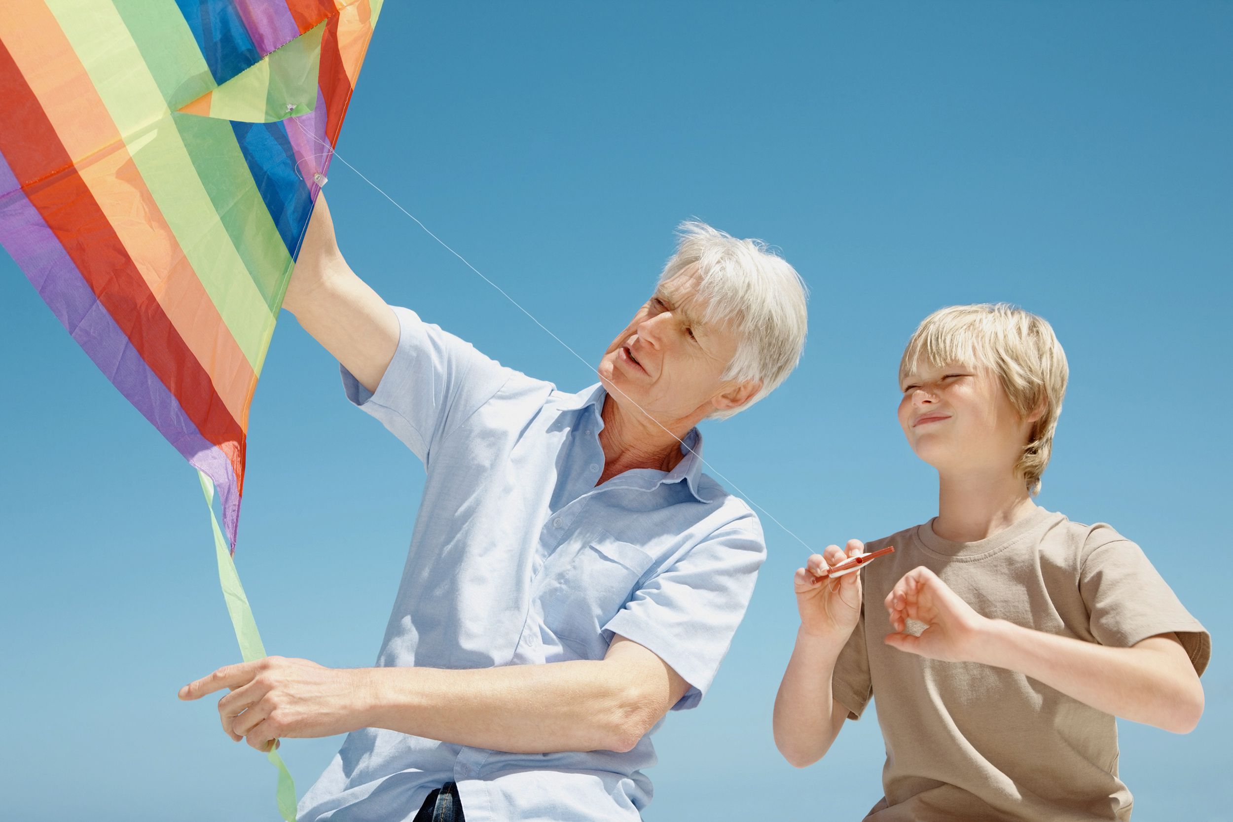 grandfather and grandson flying kite together