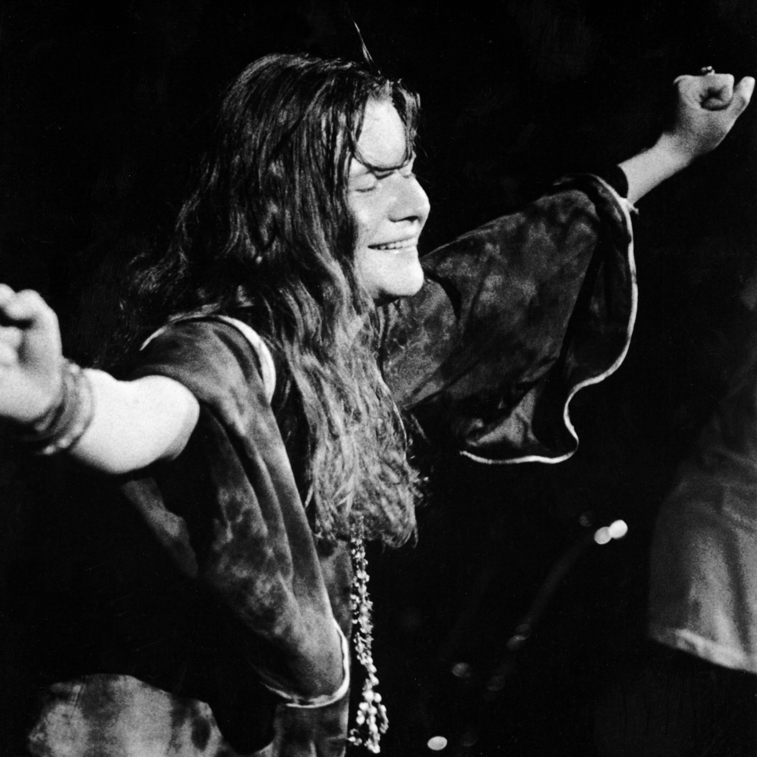 Janis Joplin (1943 - 1970) closes her eyes and outstretches her arms during a performance, late 1960