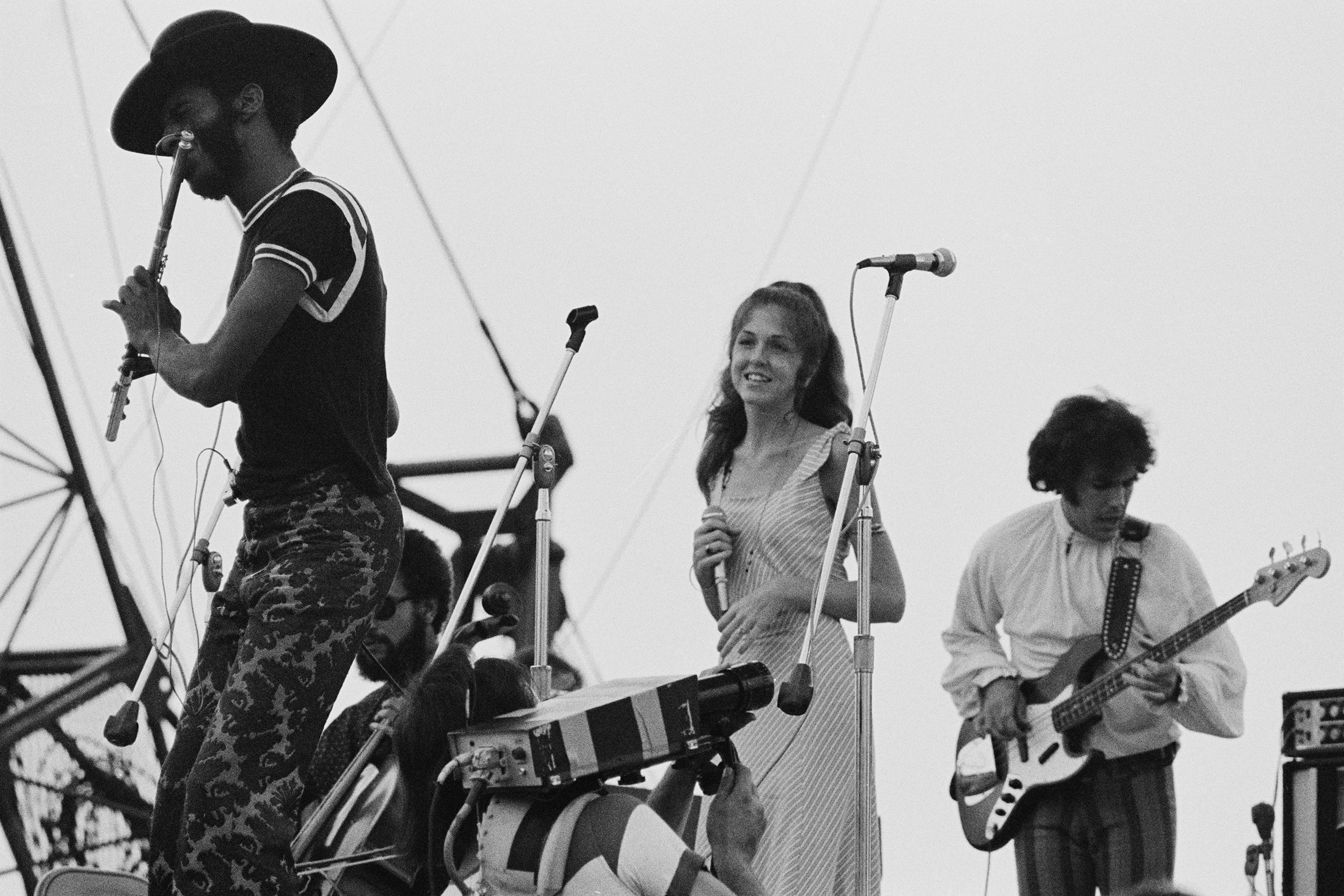 A cameraman (bottom, centre) films American rock band Sweetwater performing at the Woodstock Music Festival