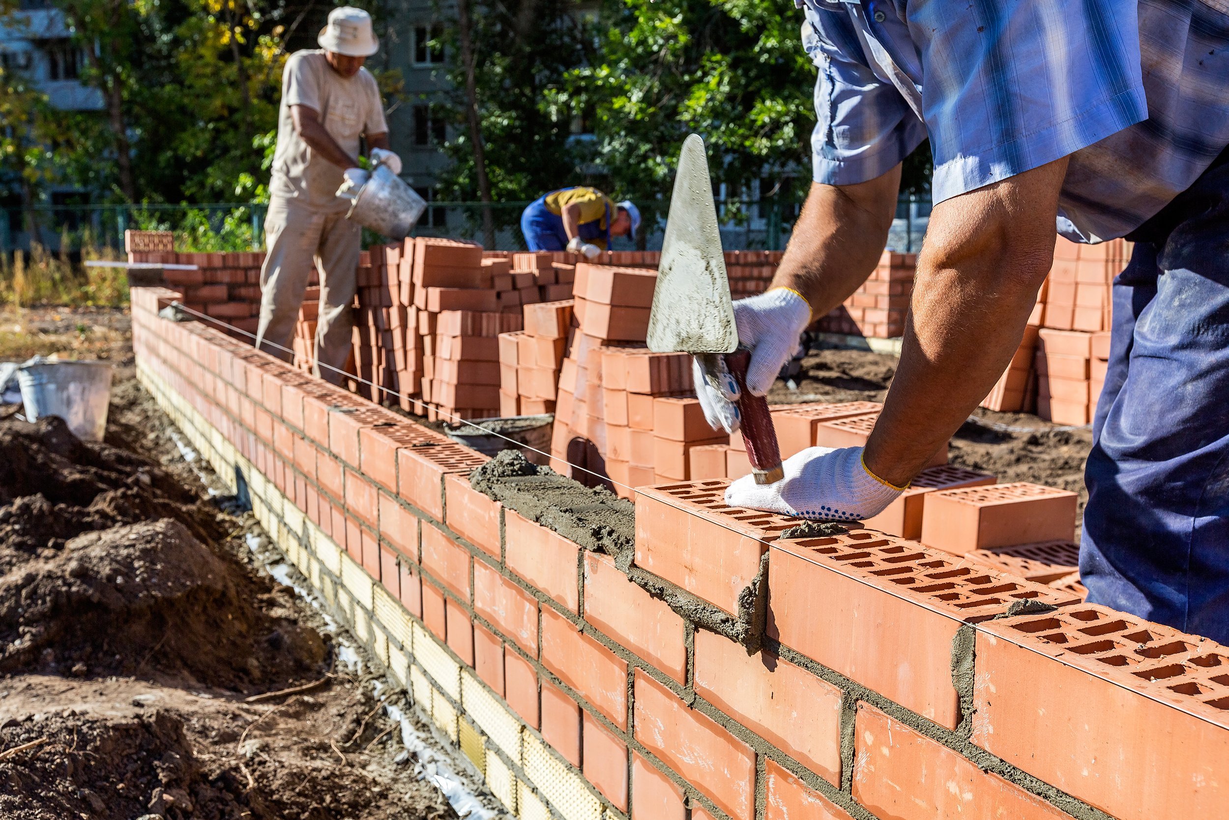 Manual laborers laying bricks