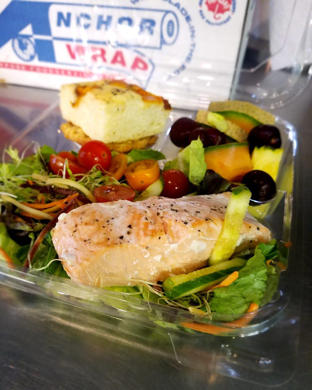 prepared mixed green salad with sprouts, tomatoes and cucumber, served with focaccia, fresh fruit
