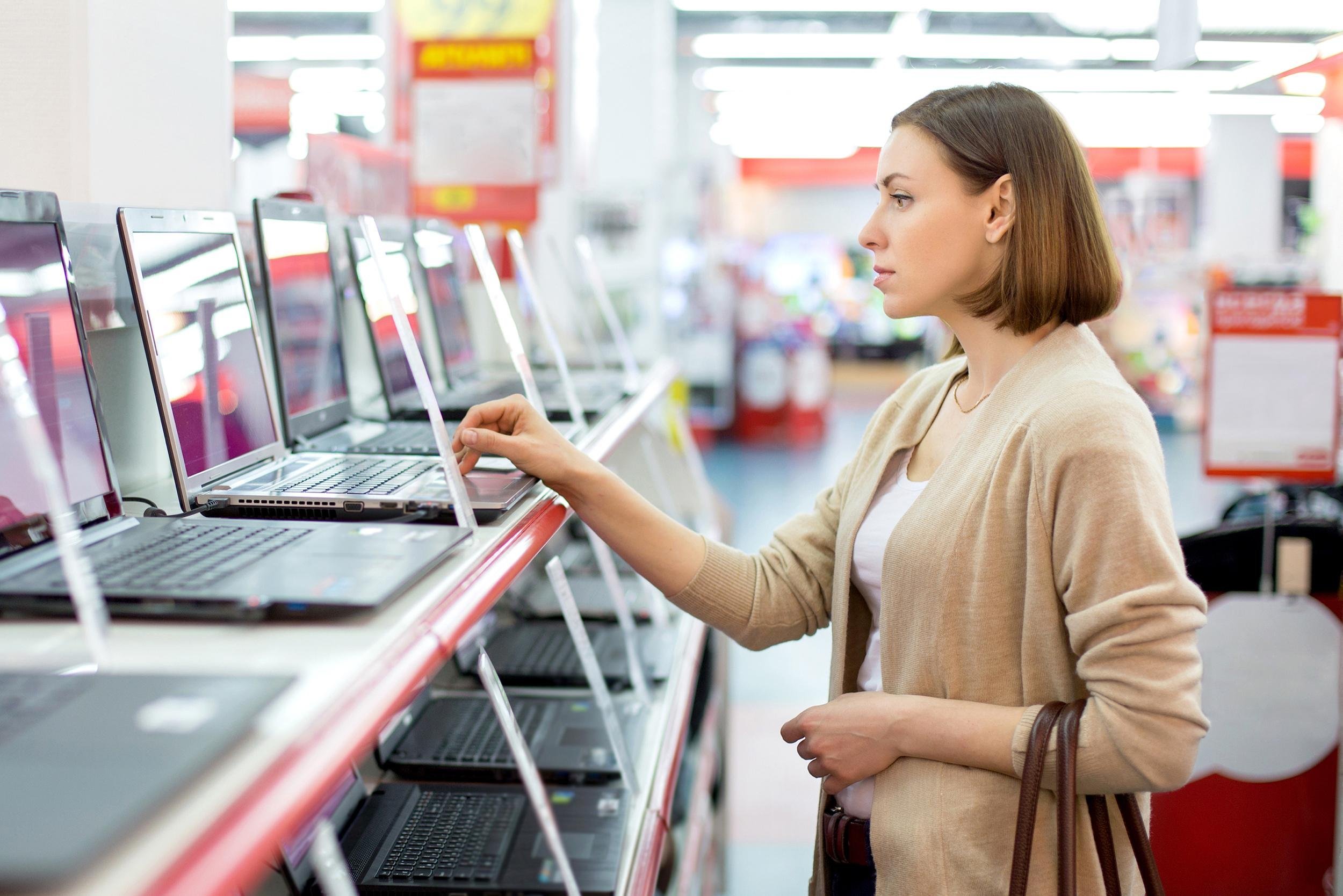 woman looking at laptops in store