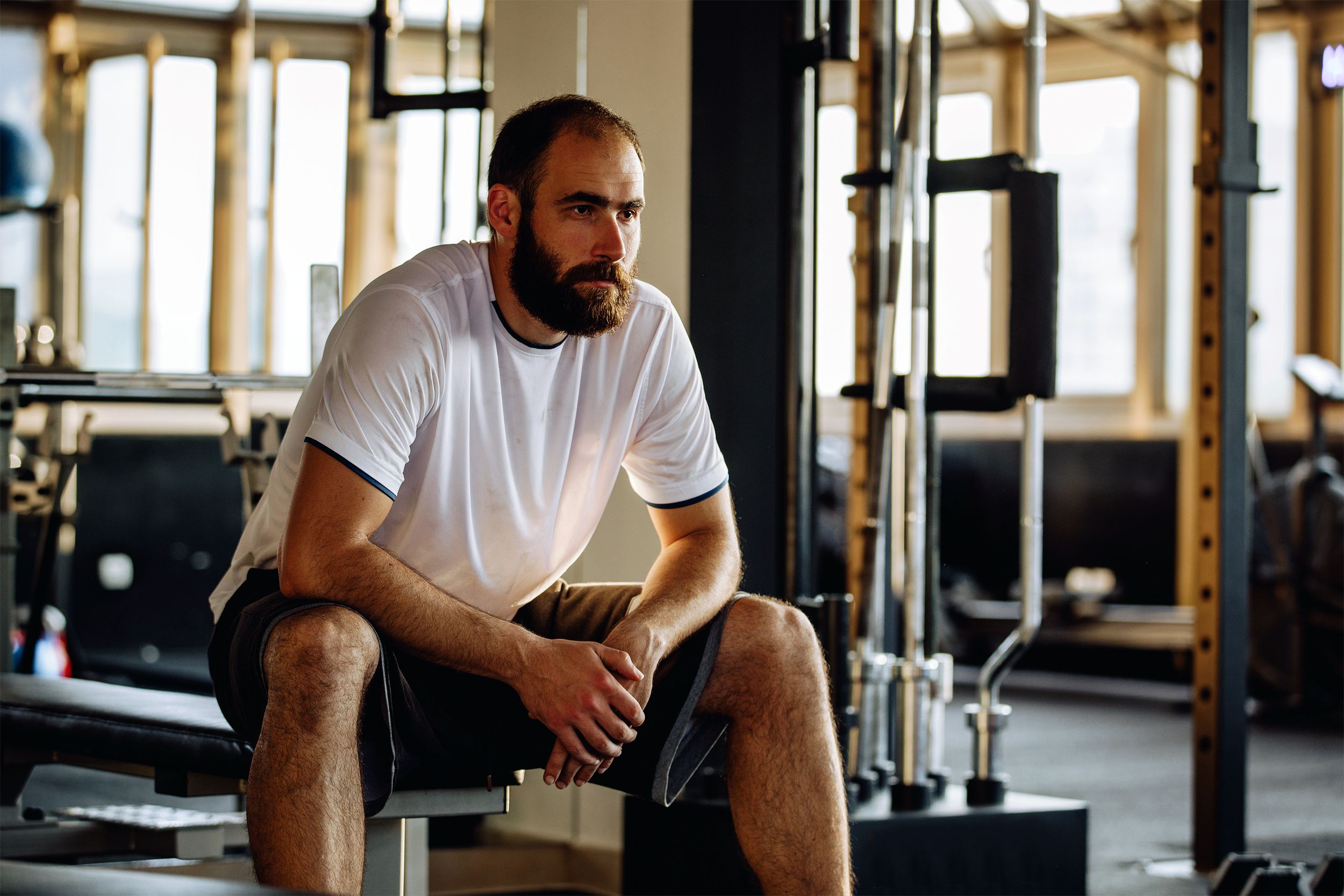 Man sitting on a weight bench at the gym