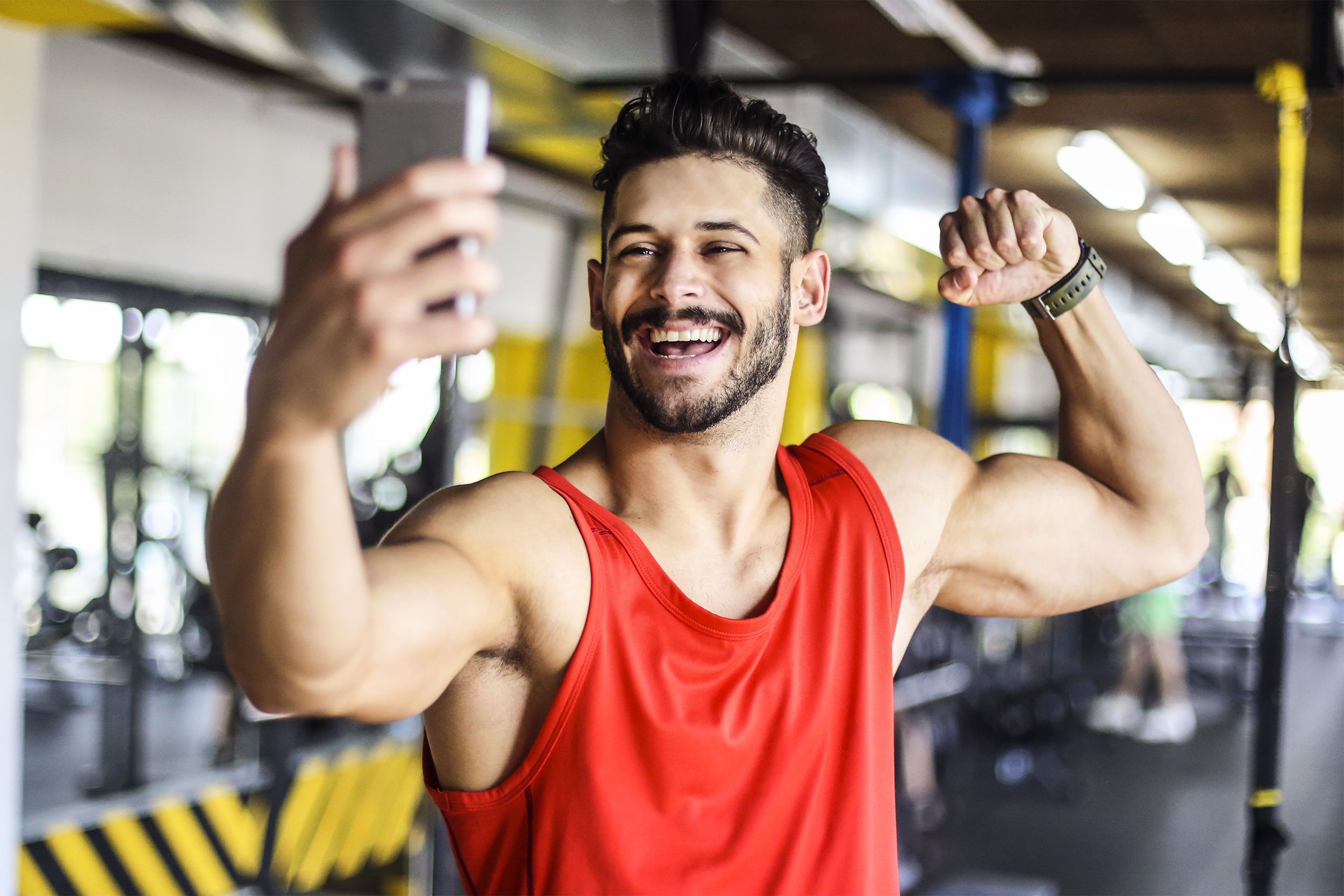 Muscular man taking a selfie in the gym