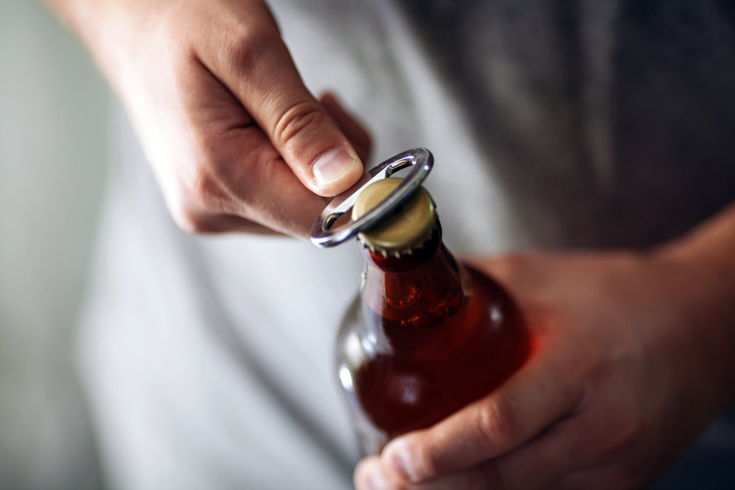 Man opening a beer with a bottle opener