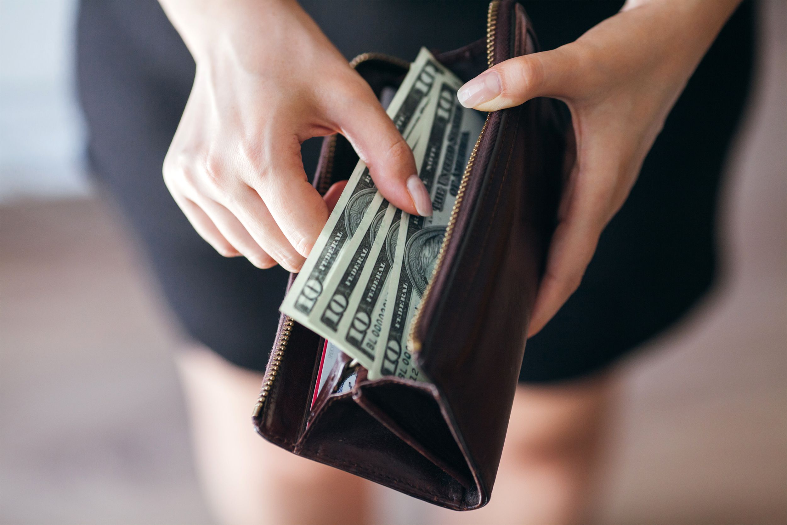 Woman taking money out of her wallet