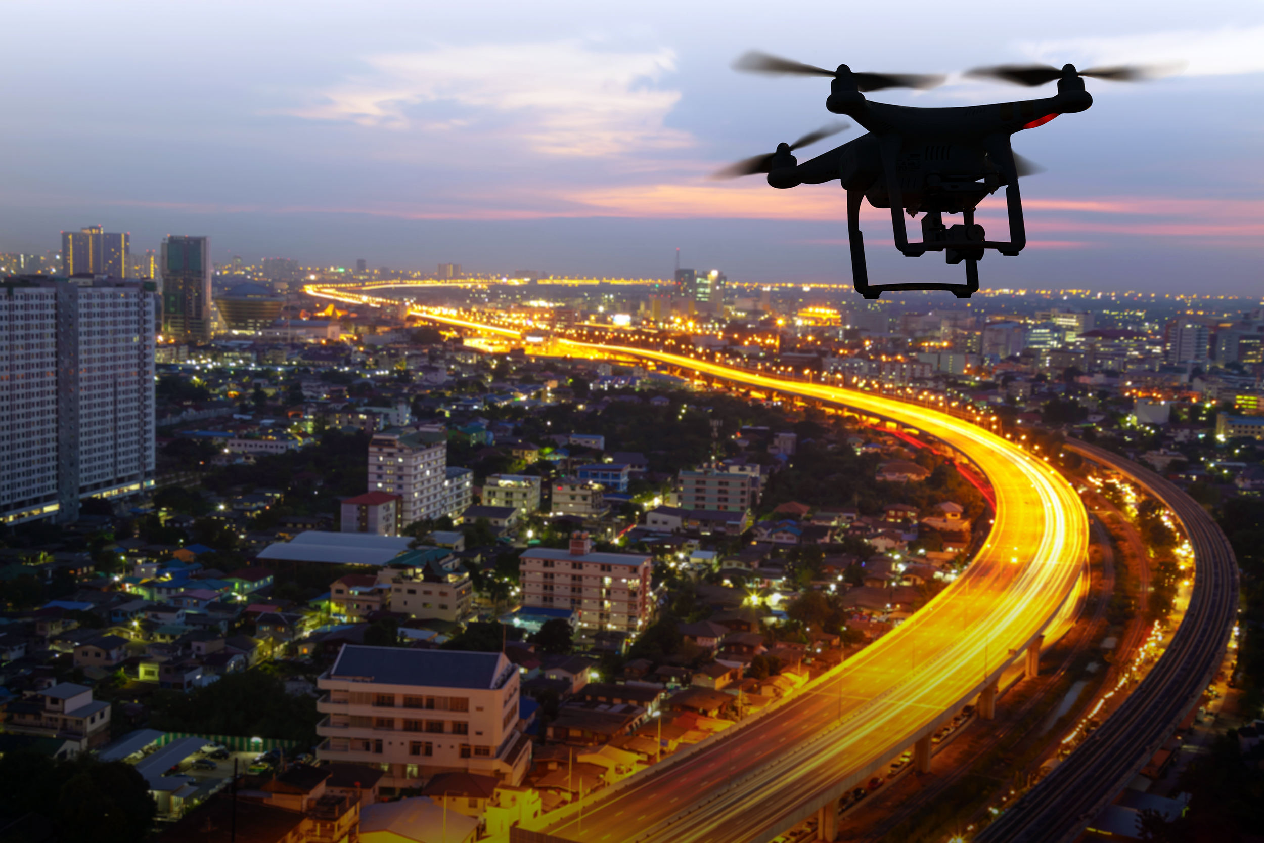 Drone flying over a city at dusk