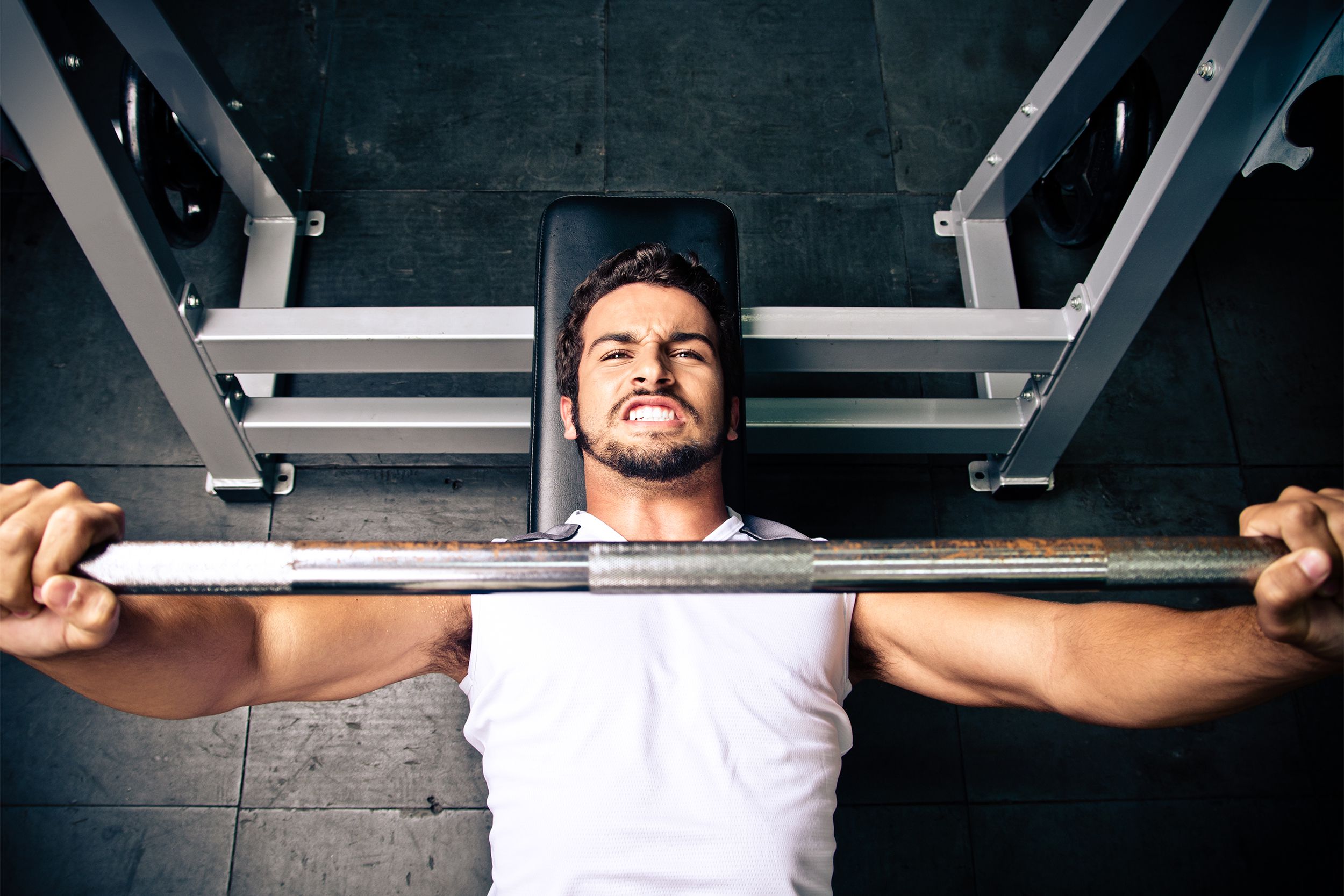 Man grunting while using a bench press