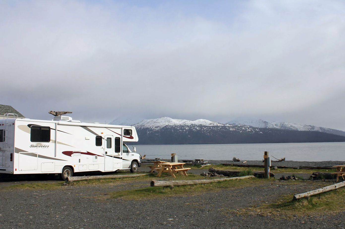 beach view of homer spit campground with rv in foreground, mountains and beach in background