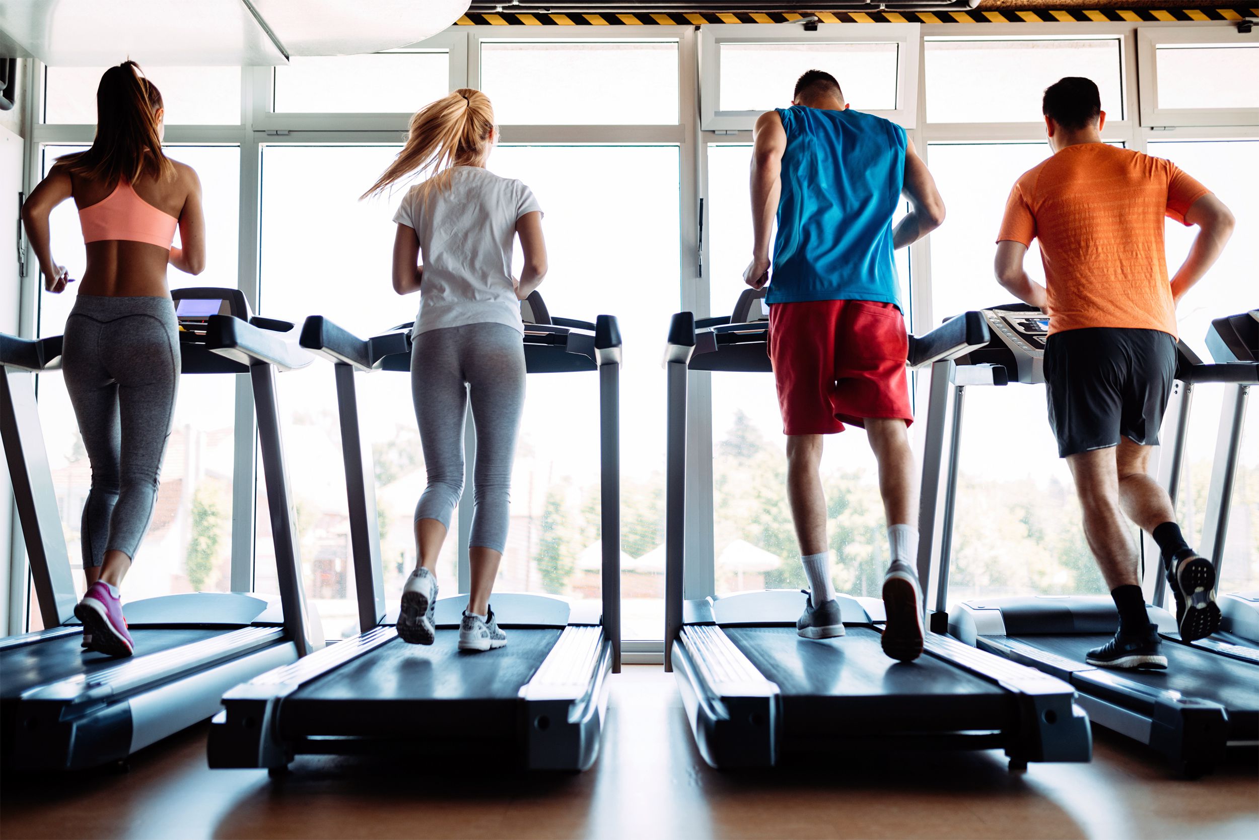 People running on treadmills in a gym