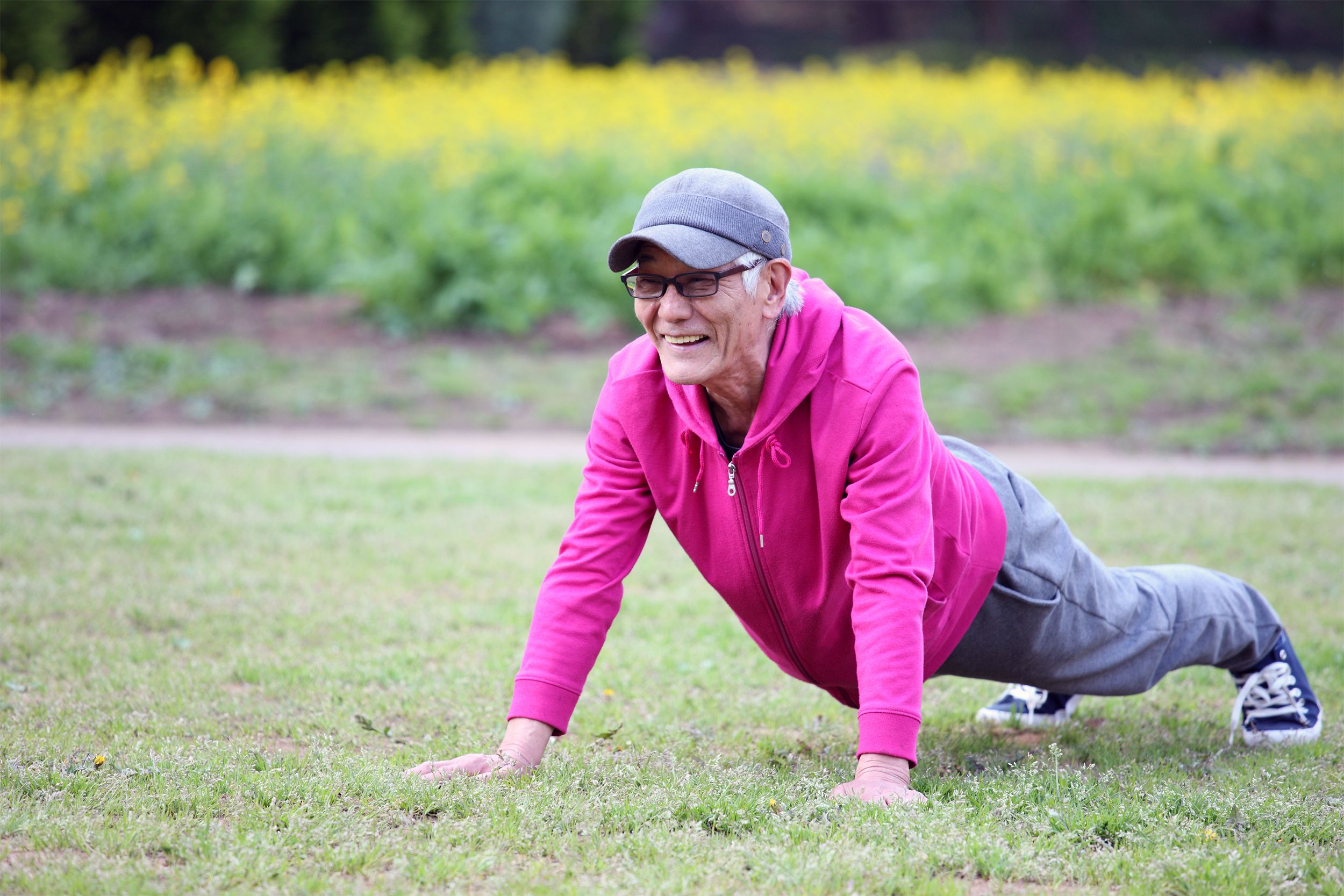 Senior man in push up position on outdoor lawn