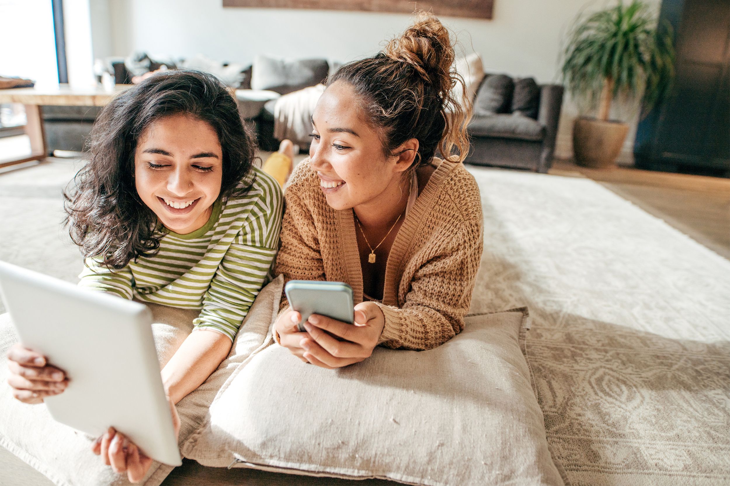 Two friends on their phone and laptop