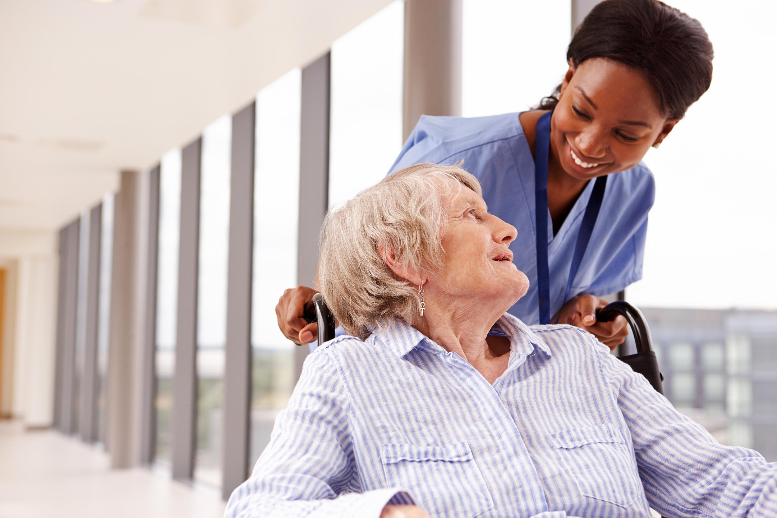 Hospital orderly moving a woman in a wheelchair