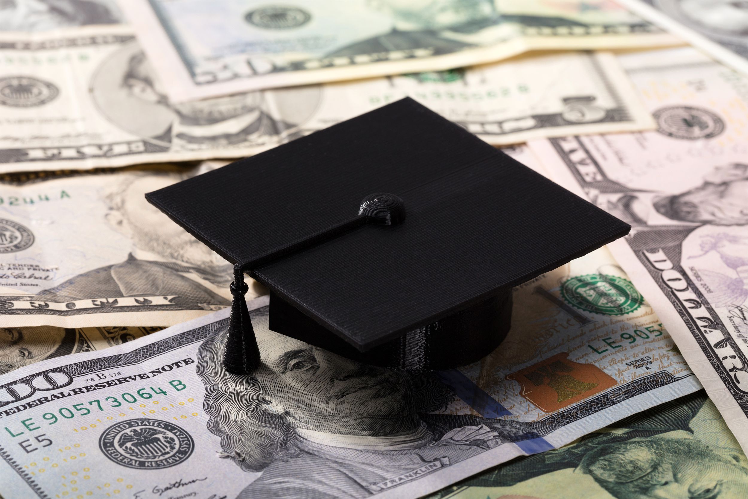 Graduation cap sitting on money