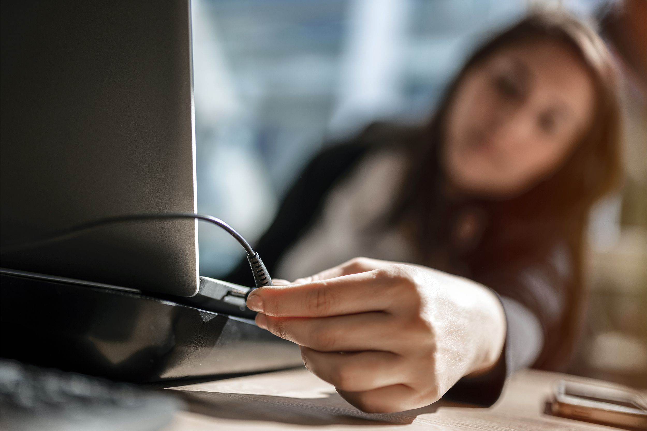 Blurred woman unplugging her laptop