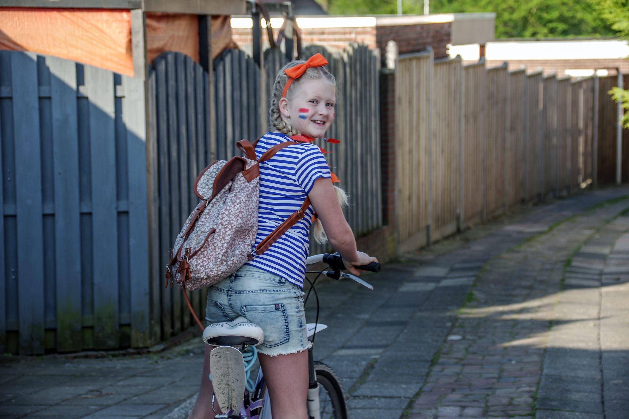 dutch schoolgirl on bike carrying backpack