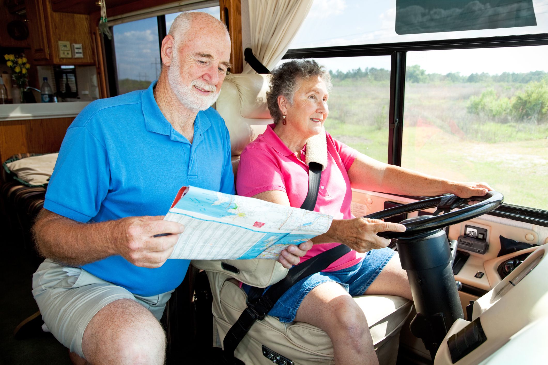 couple driving rv and looking at map