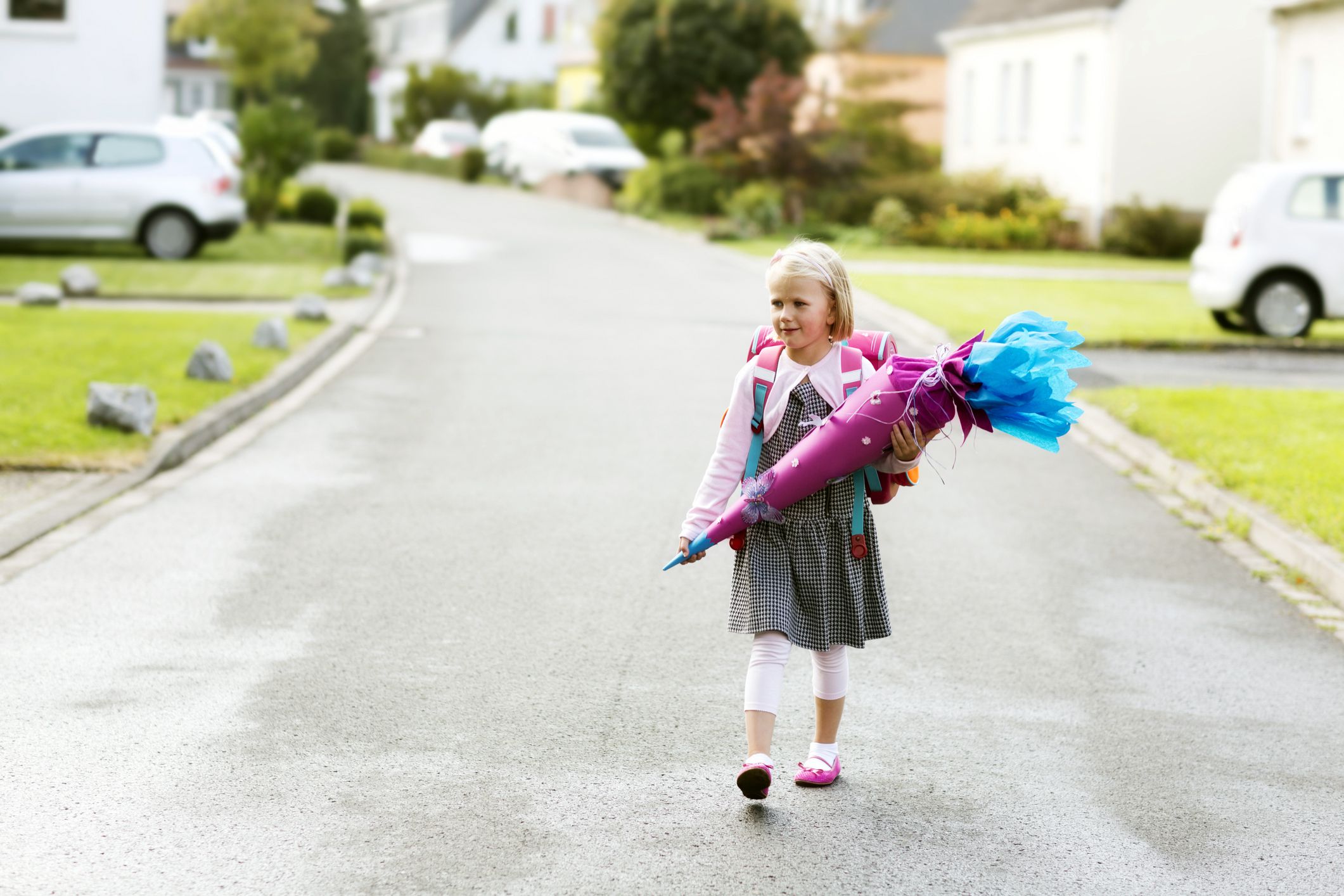 child carrying schultüte walking down residential street