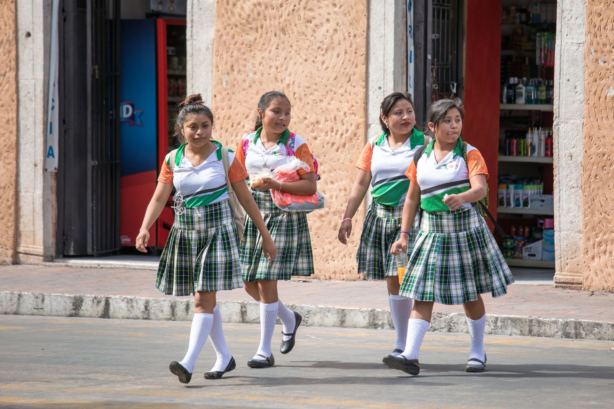 mexicano students with backpacks walking across the street