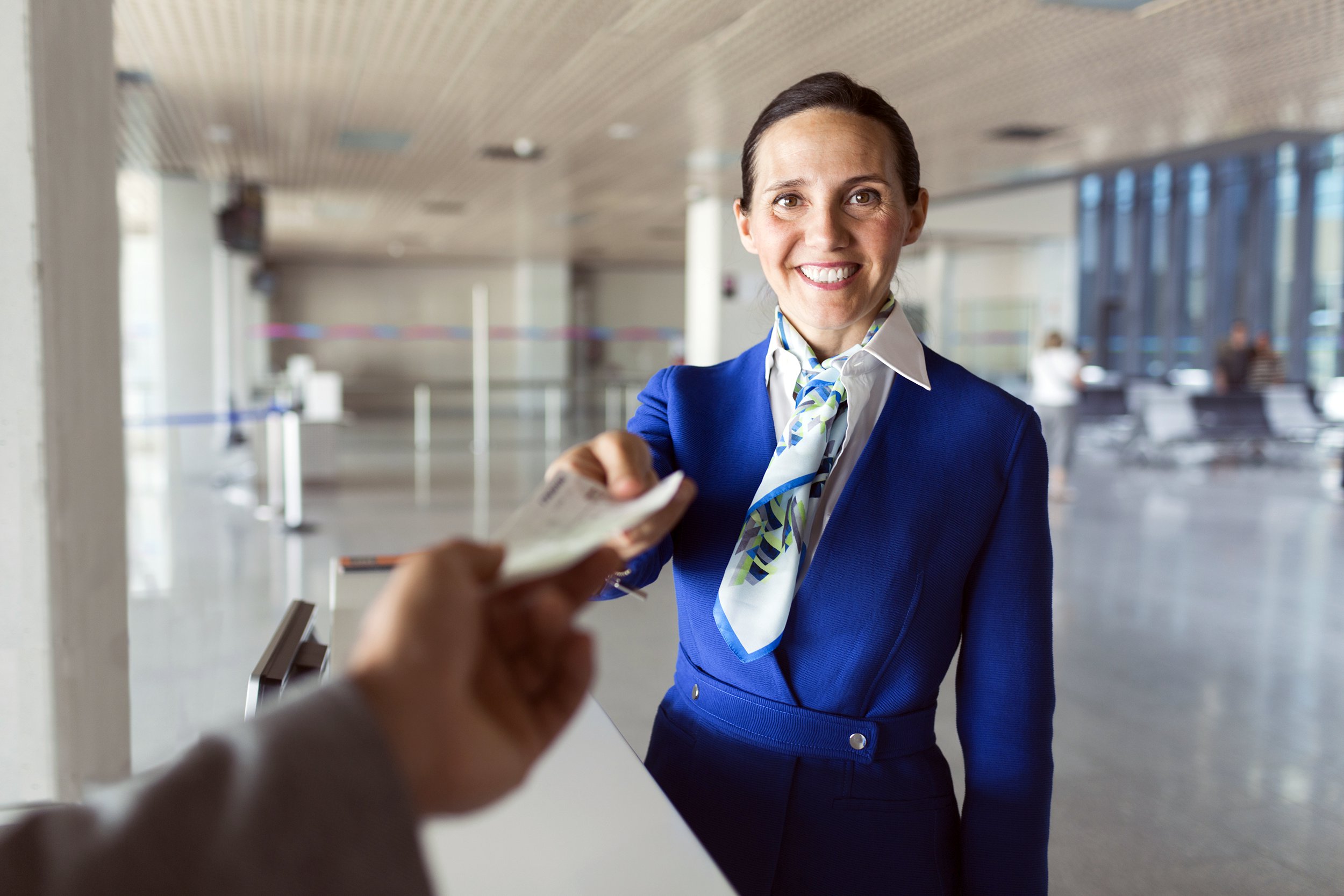 Airline employee handing boarding pass to a traveler