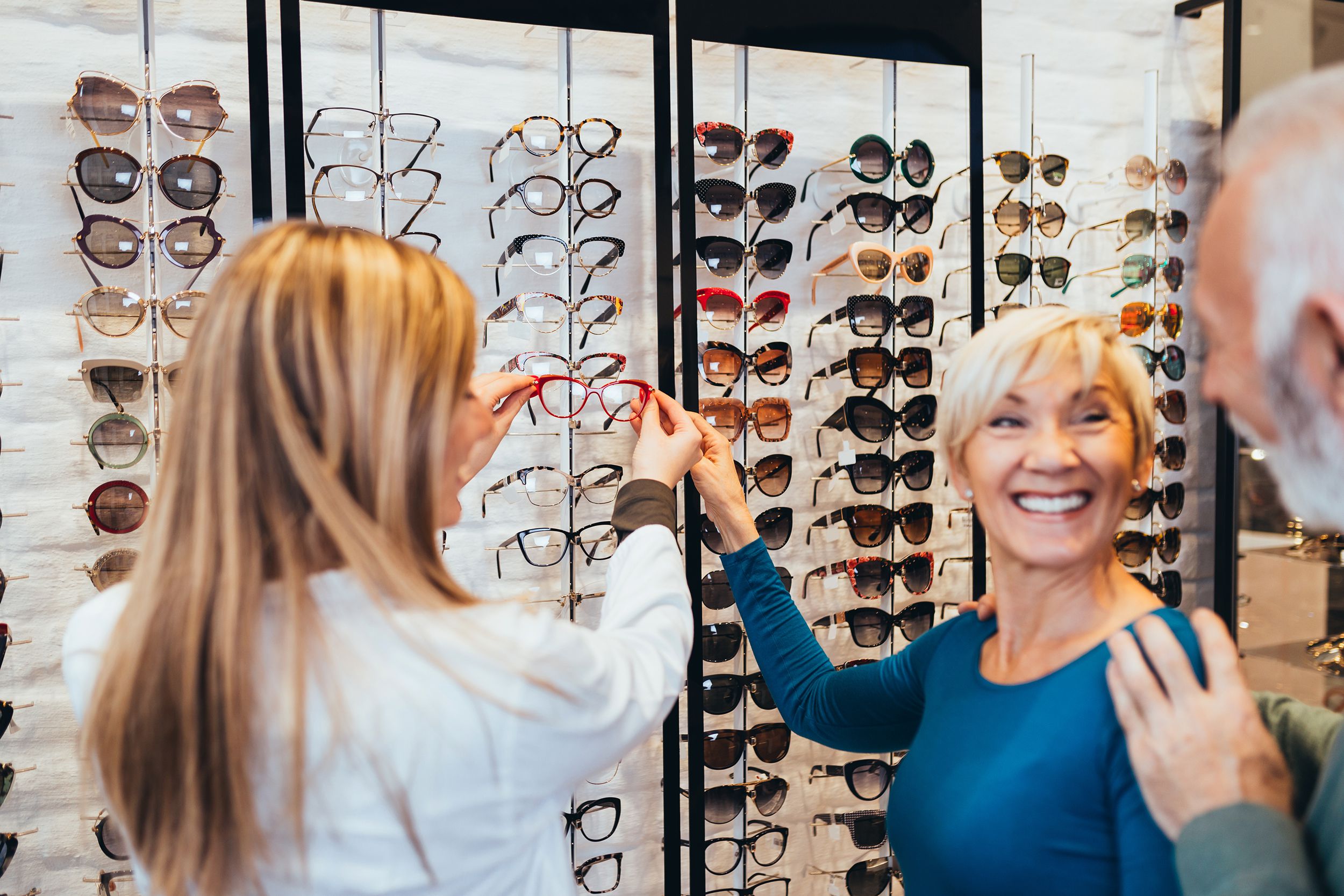 senior woman buying glasses in eye glass store
