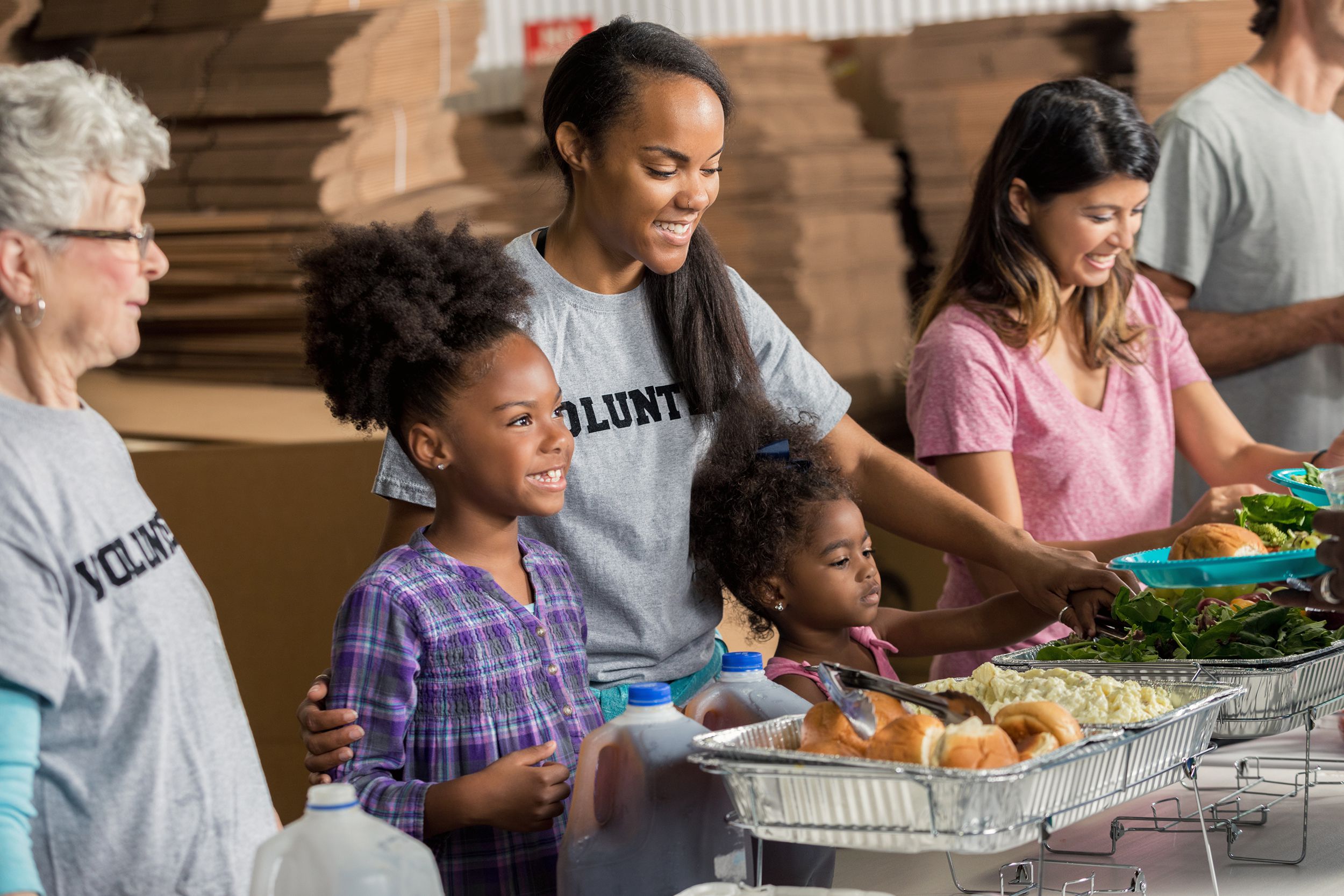diverse family volunteers together in soup kitchen