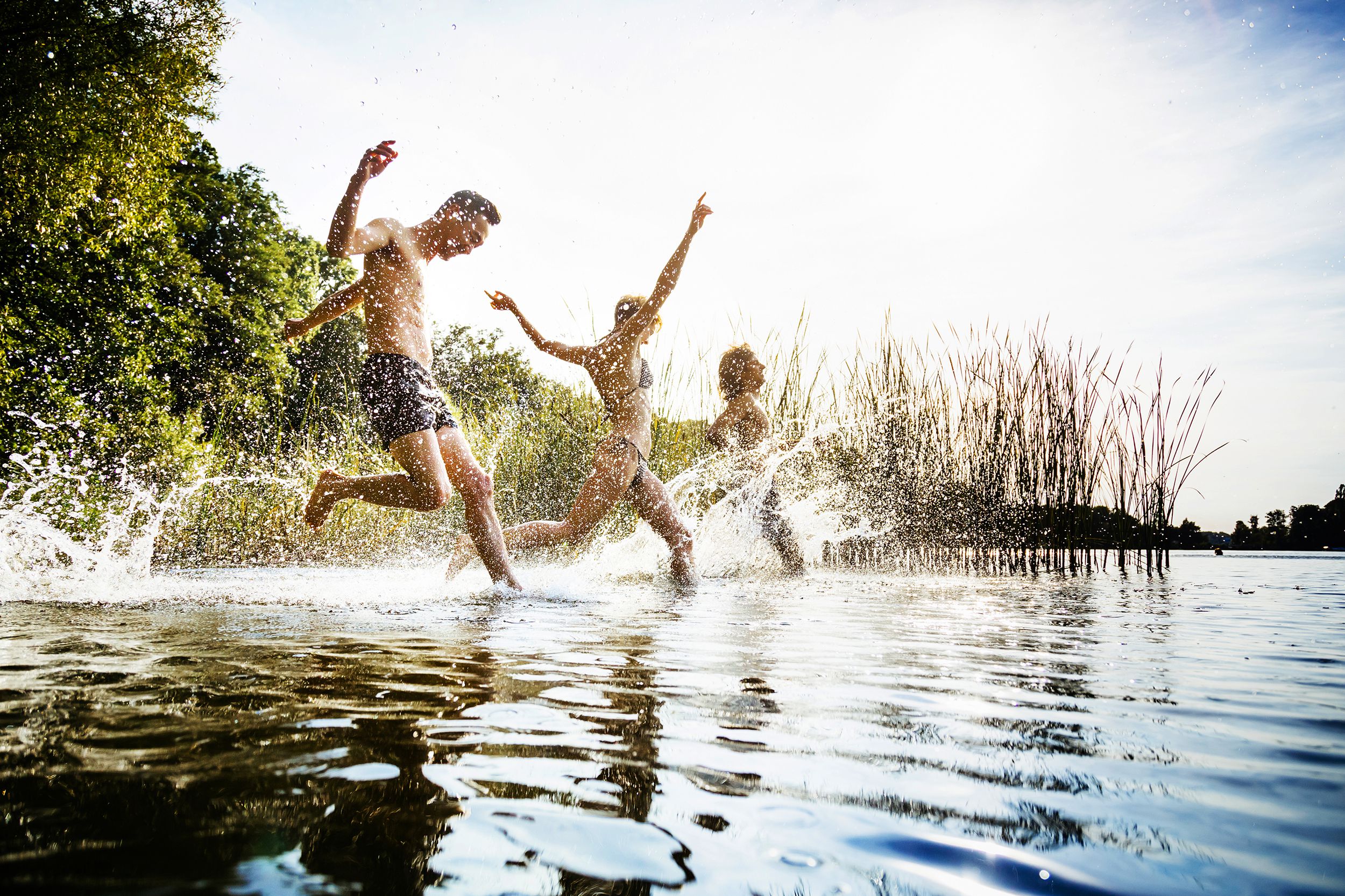 friends running into lake to swim