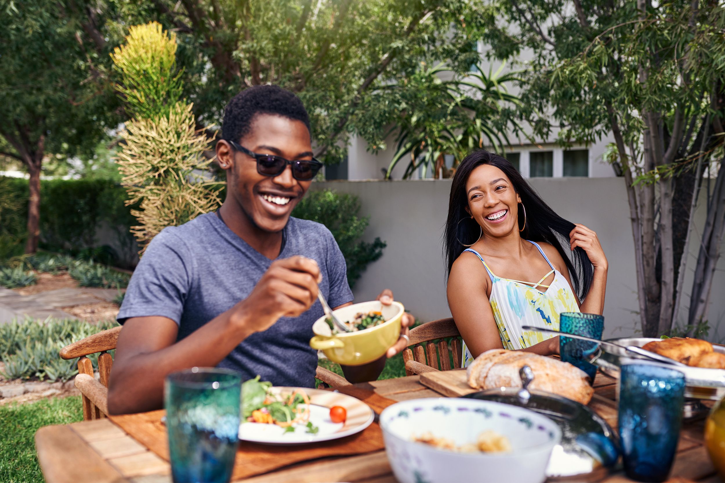 couple at table outside eating barbecue