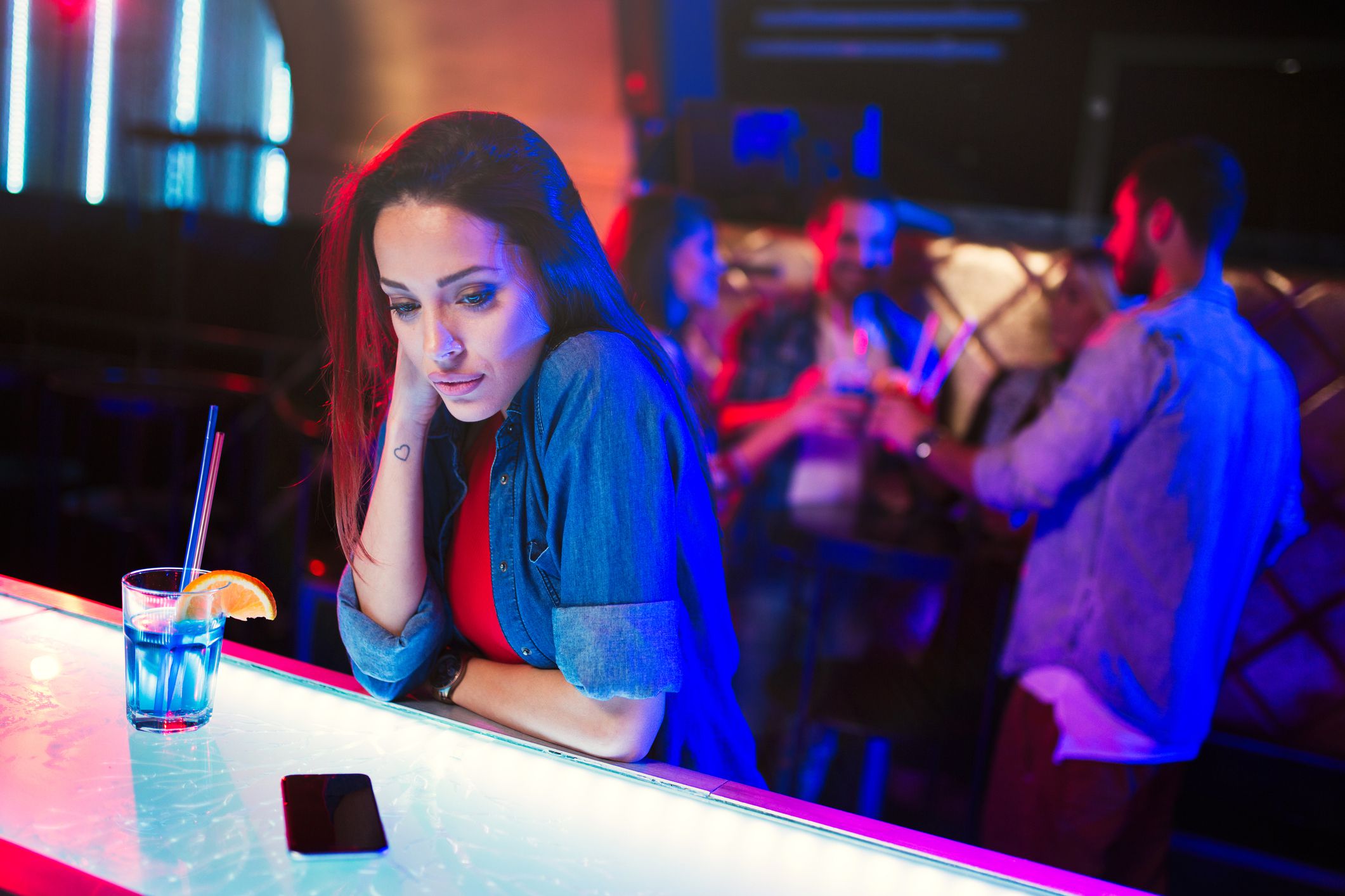 woman sitting unhappily at bar