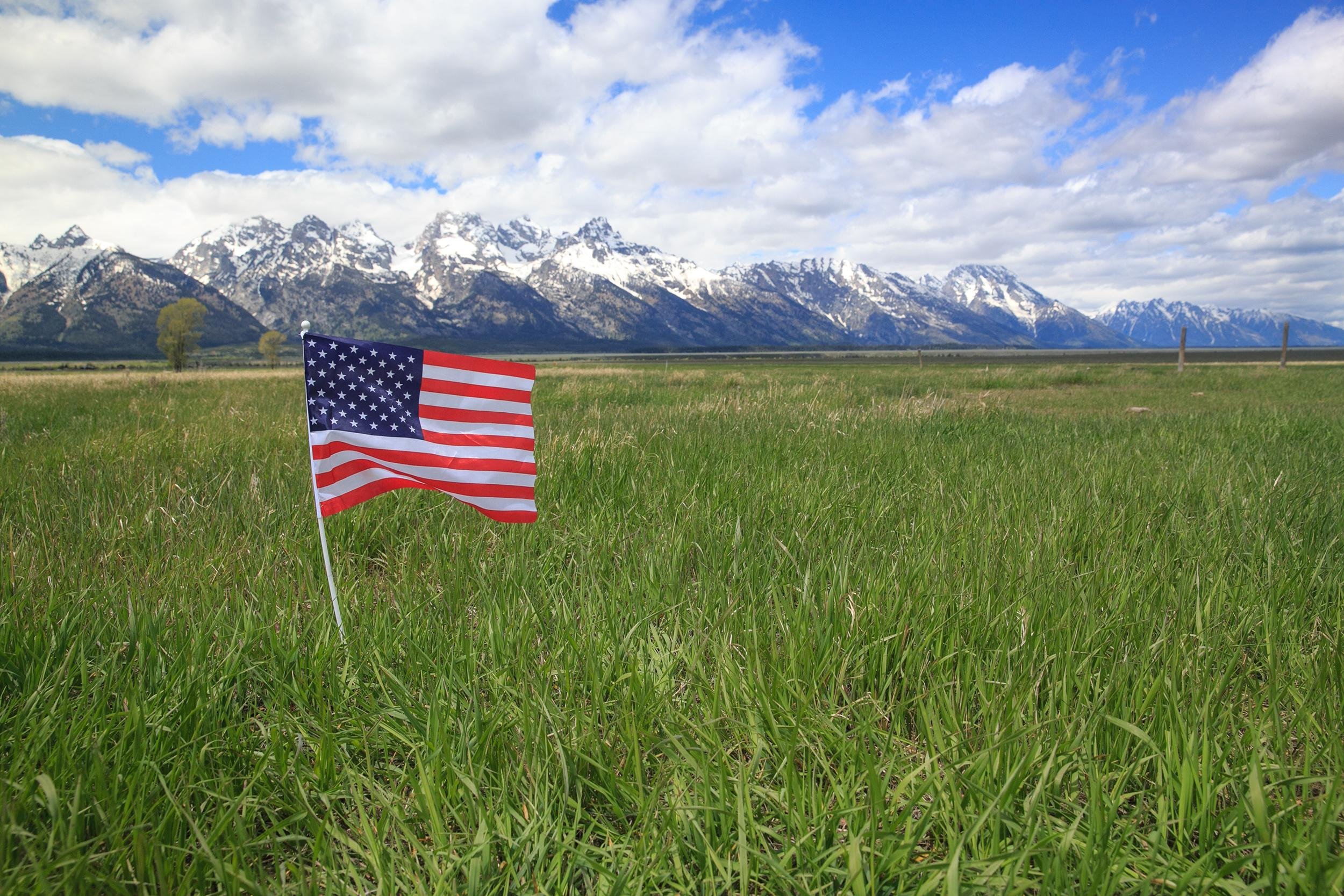 American Flag on green meadow in the Rocky Mountains