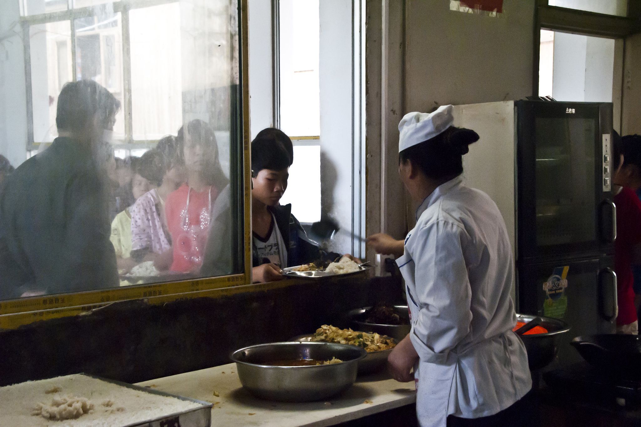 school lunch being served at canteen in zhaoxing, china, 2012