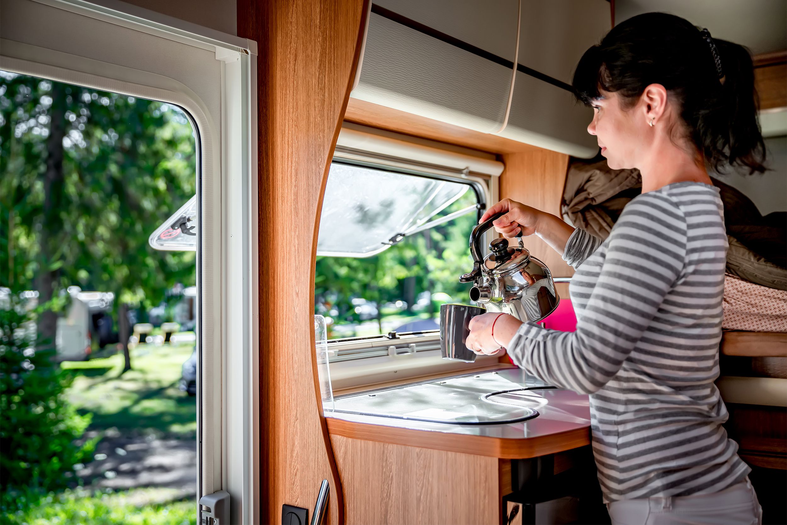 Woman pouring a cup of tea in her RV