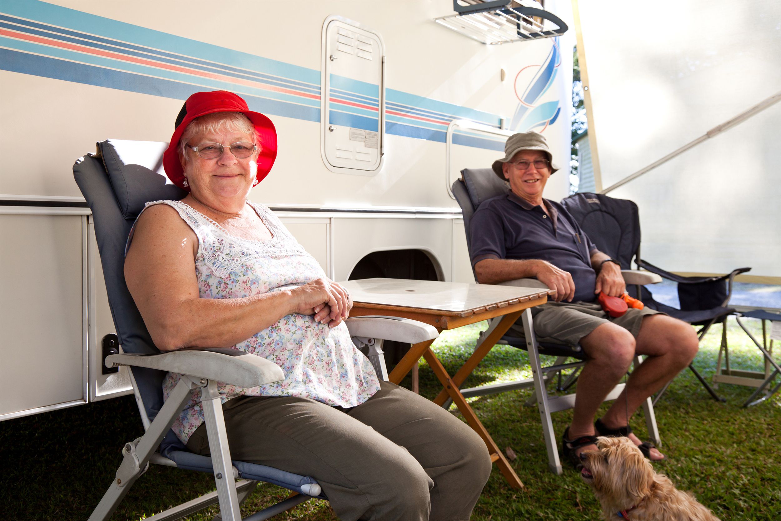 Happy senior couple sitting outside of their RV