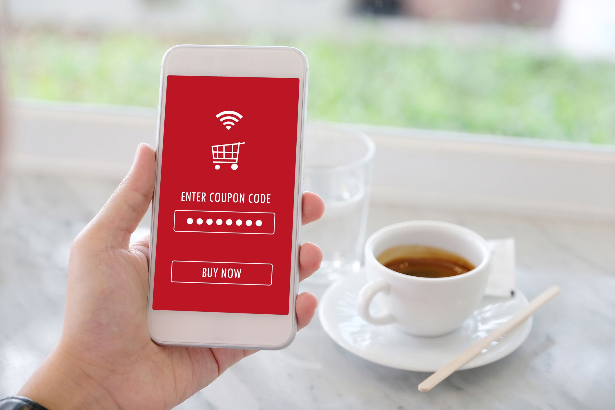 digital grocery coupon code on grocery app on smartphone, coffee in background
