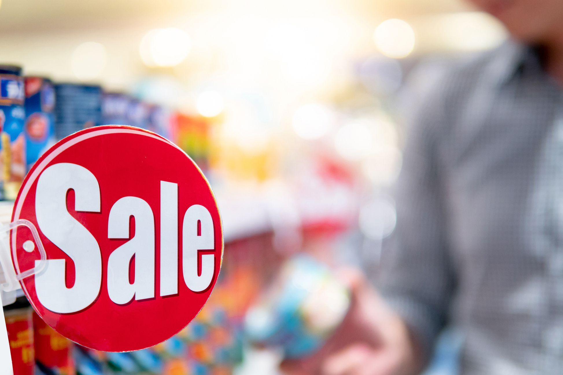 grocery sale tag in store, shopper in background